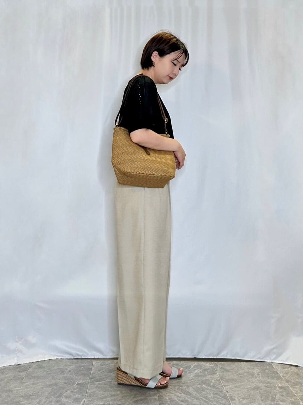 ブラック系のTシャツ/カットソー、ベージュ系のその他パンツ、シルバー系のサンダルを着用したレディースの夏コーディネートの2枚目の写真