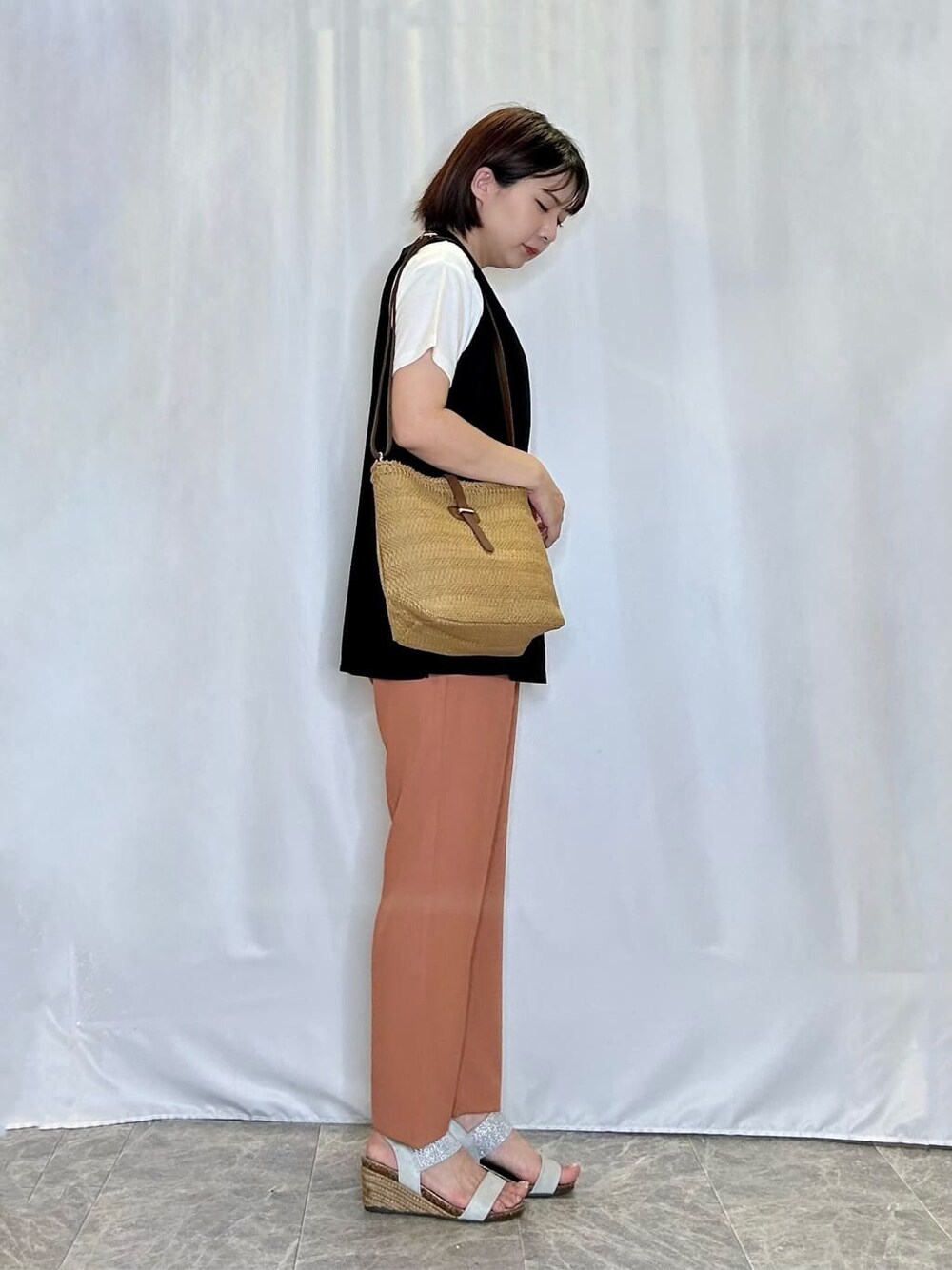 ブラック系のその他トップス、オレンジ系のその他パンツ、シルバー系のサンダルを着用したレディースの夏コーディネートの2枚目の写真