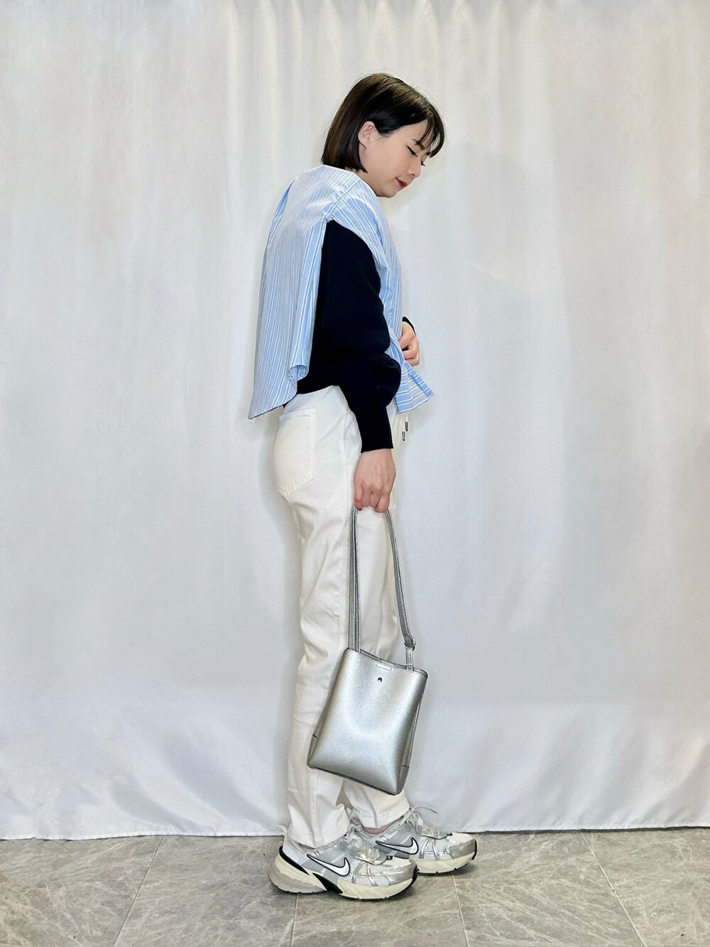 ホワイト系のその他パンツ、シルバー系のショルダーバッグ、ブルー系のシャツ/ブラウスを着用したレディースの春コーディネートの2枚目の写真
