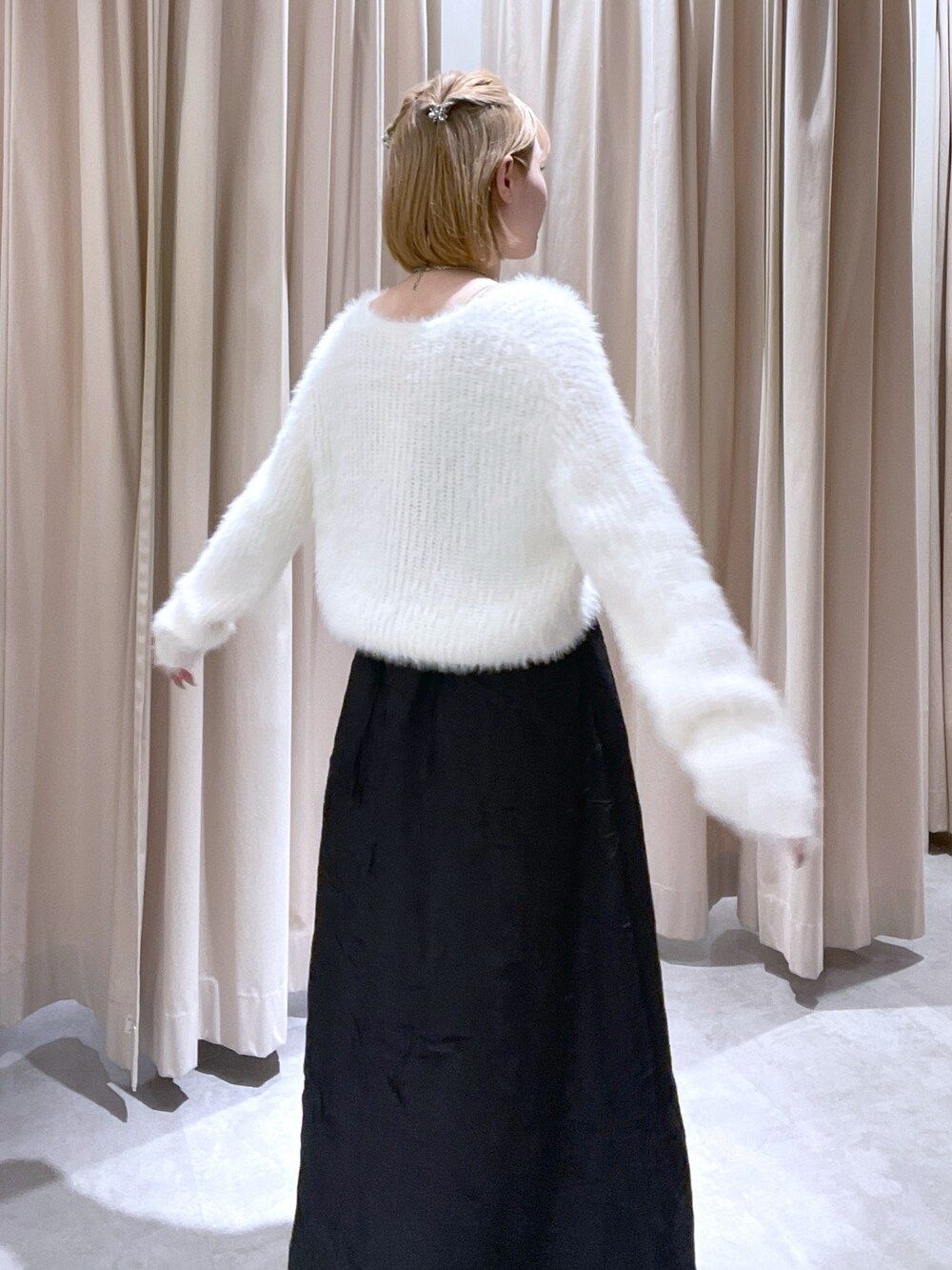 ホワイト系のカーディガン/ボレロ、ブラック系のワンピースを着用したレディースの冬コーディネートの2枚目の写真