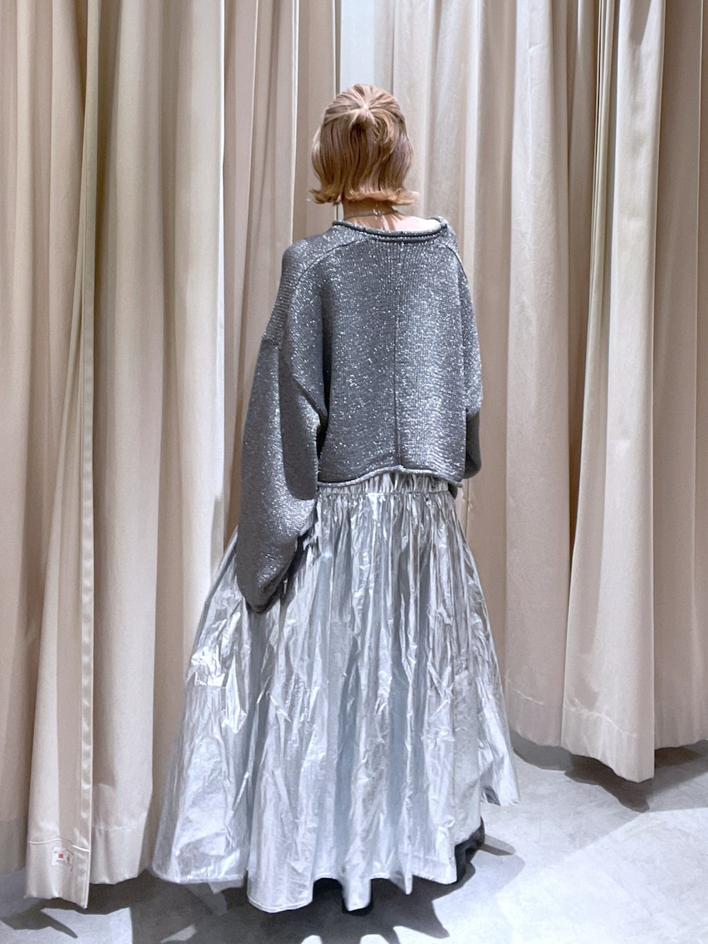 シルバー系のスカートを着用したレディースの春コーディネートの2枚目の写真