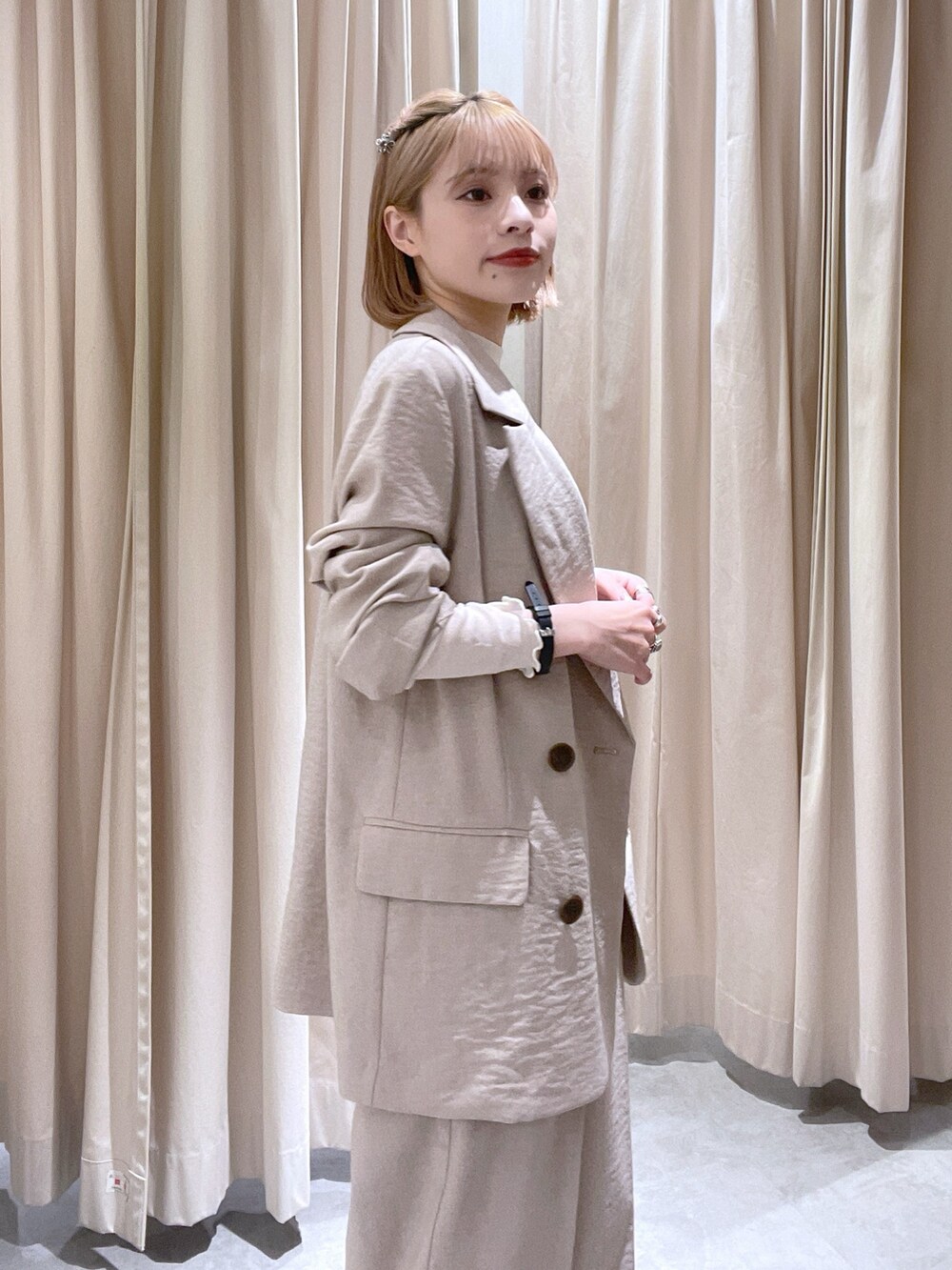 ベージュ系のスラックス、ベージュ系のテーラードジャケット、ホワイト系のTシャツ/カットソーを着用したレディースの春コーディネートの2枚目の写真
