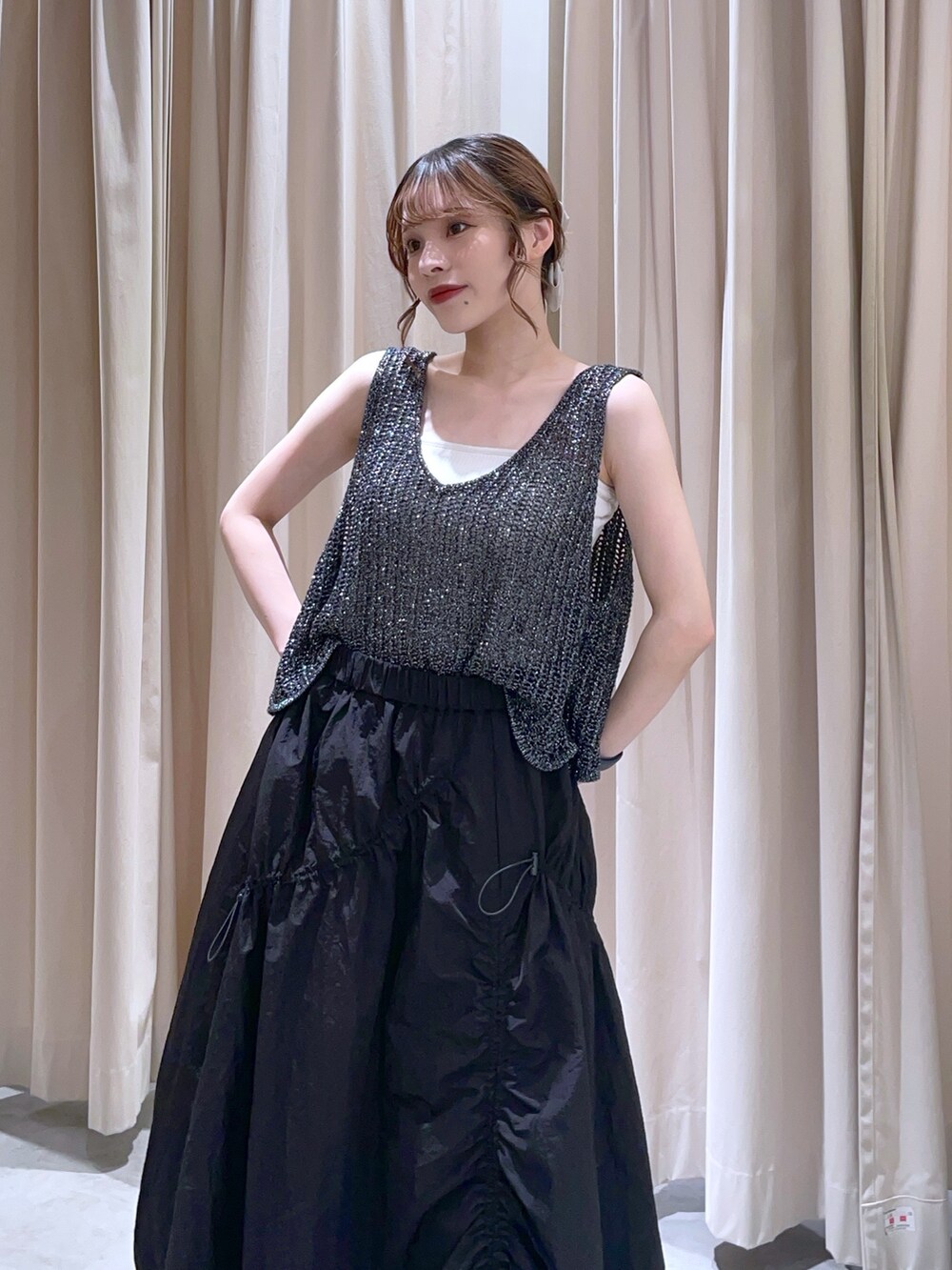 ブラック系のベスト、ブラック系のスカートを着用したレディースの夏コーディネートの2枚目の写真