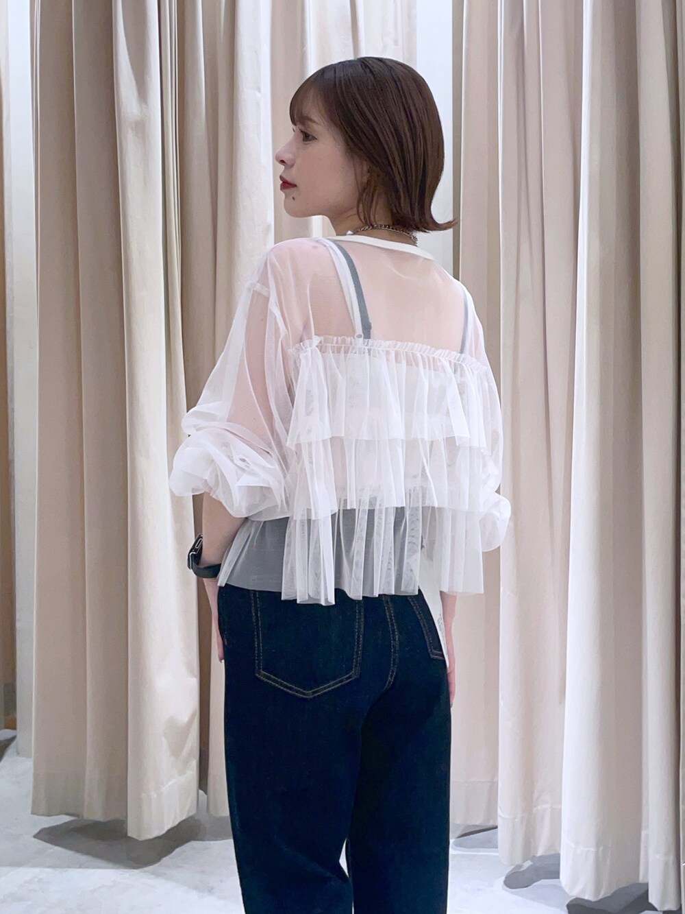 ホワイト系のシャツ/ブラウス、ブルー系のデニムパンツを着用したレディースの春コーディネートの2枚目の写真