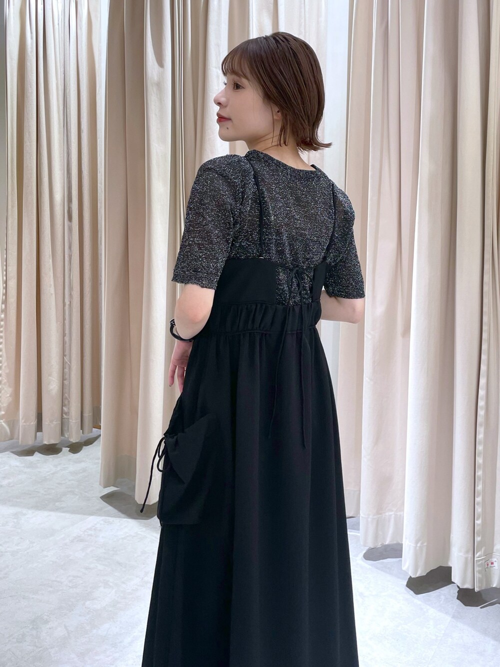 ブラック系のニット/セーター、ブラック系のワンピースを着用したレディースの春コーディネートの2枚目の写真