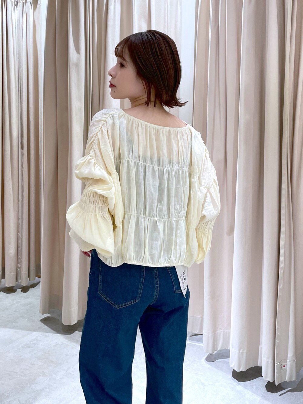 イエロー系のカーディガン/ボレロ、ブルー系のデニムパンツを着用したレディースの春コーディネートの2枚目の写真