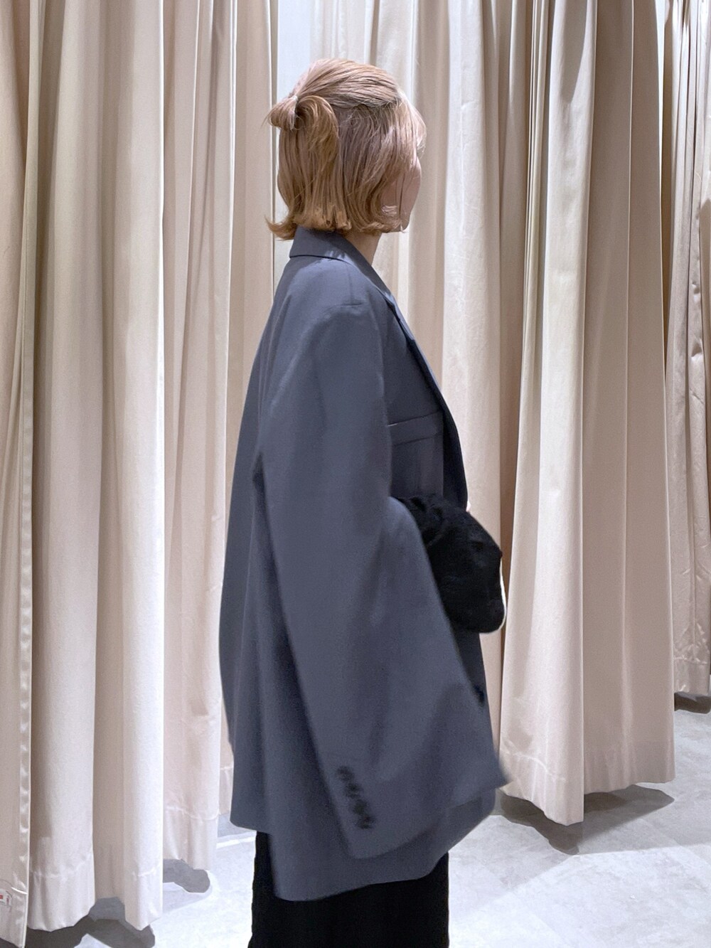 グレー系のテーラードジャケット、ブラック系のワンピースを着用したレディースの春コーディネートの2枚目の写真