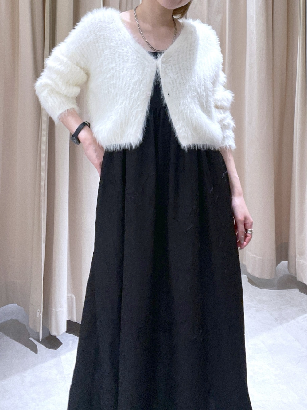 ホワイト系のカーディガン/ボレロ、ブラック系のワンピースを着用したレディースの冬コーディネートの3枚目の写真