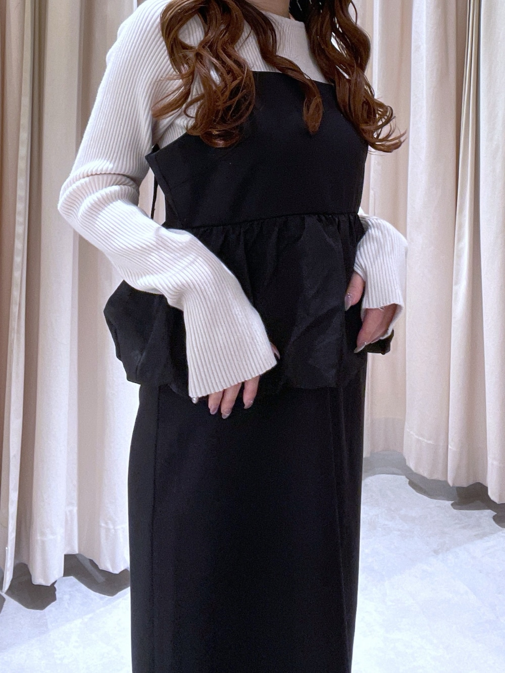 ホワイト系のニット/セーター、ブラック系のワンピースを着用したレディースの冬コーディネートの2枚目の写真