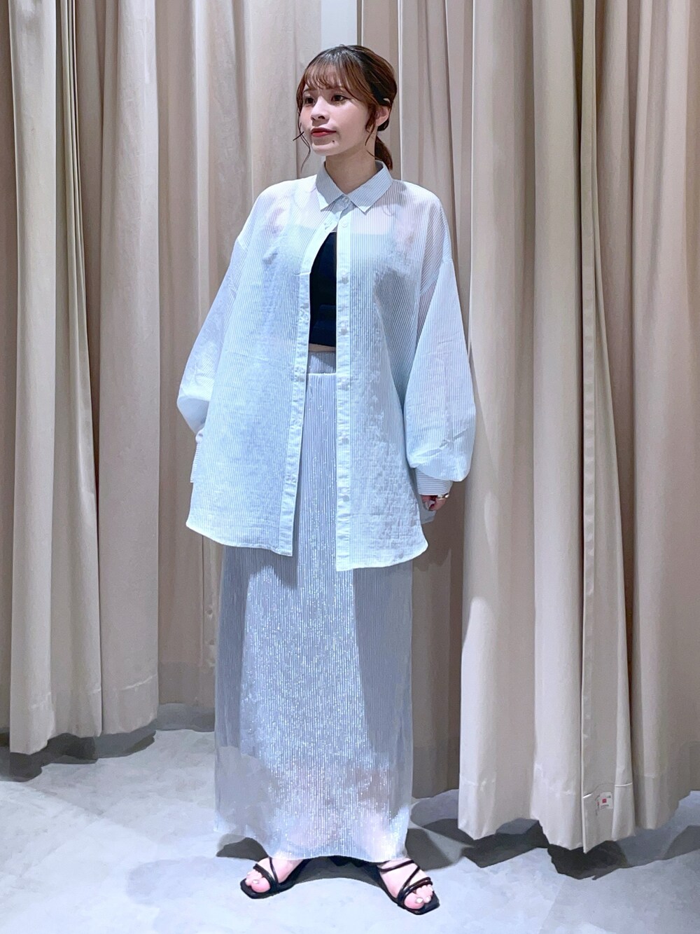ブルー系のシャツ/ブラウス、シルバー系のスカートを着用したレディースの夏コーディネートの2枚目の写真