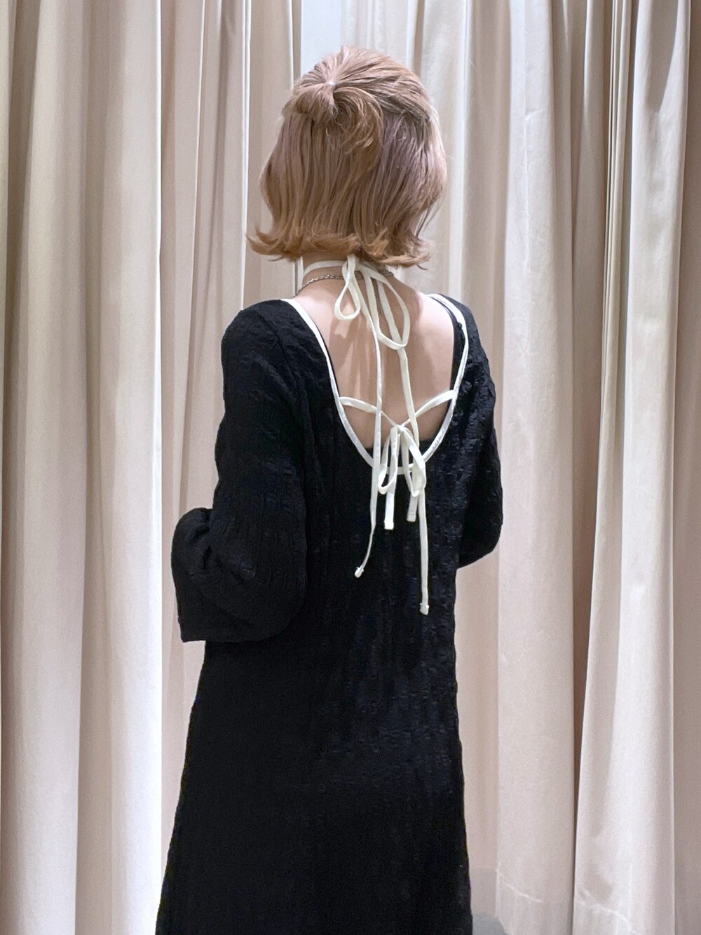 ブラック系のワンピースを着用したレディースの春コーディネートの2枚目の写真