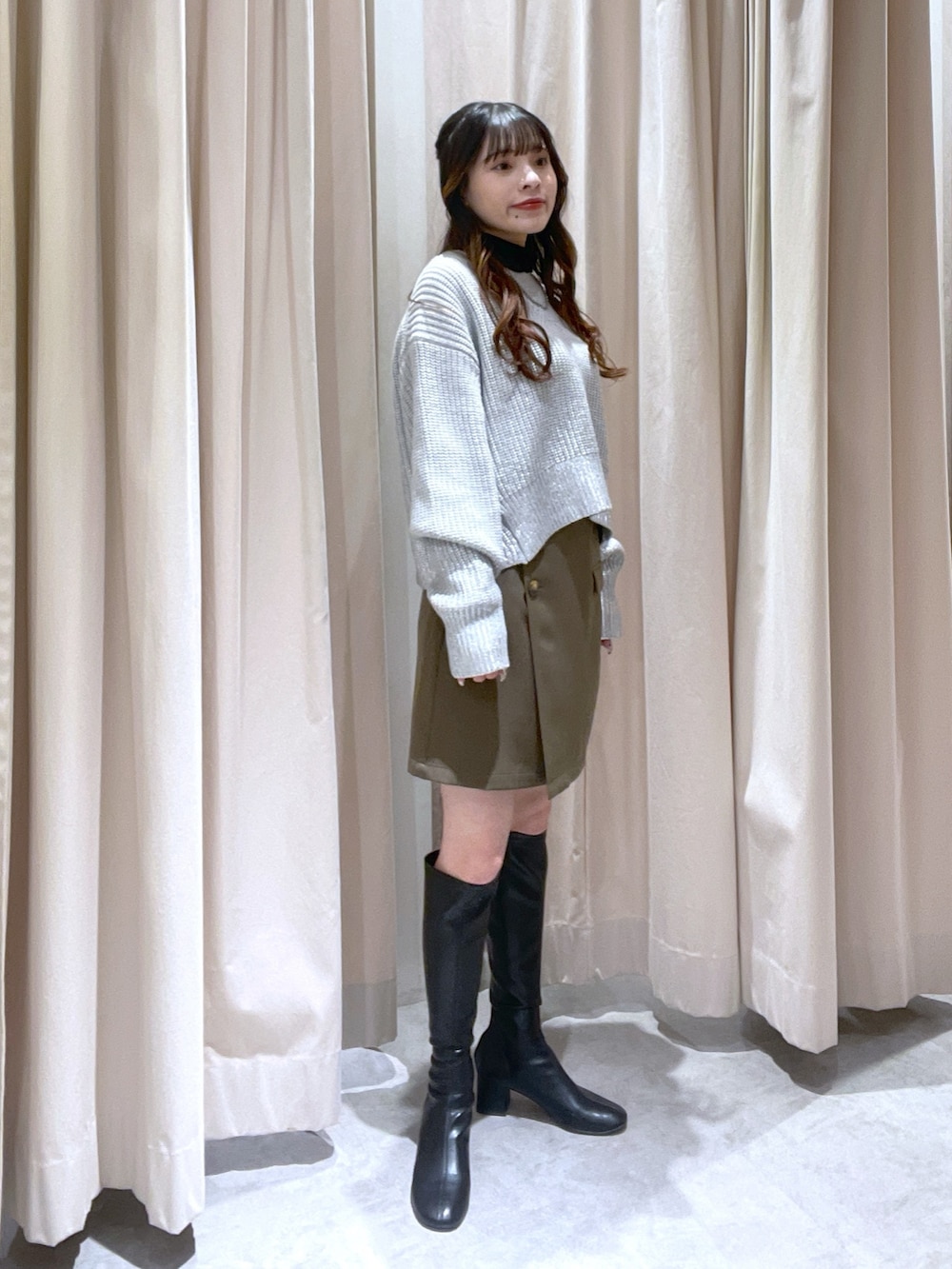 ブラウン系のスカート、グレー系のニット/セーターを着用したレディースの冬コーディネートの2枚目の写真
