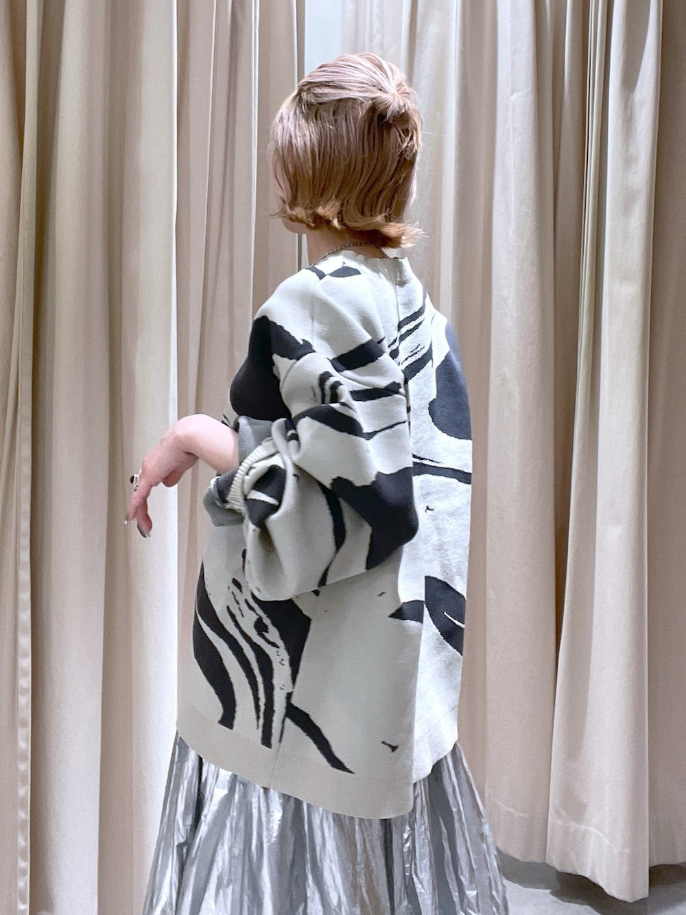 シルバー系のスカートを着用したレディースの春コーディネートの2枚目の写真