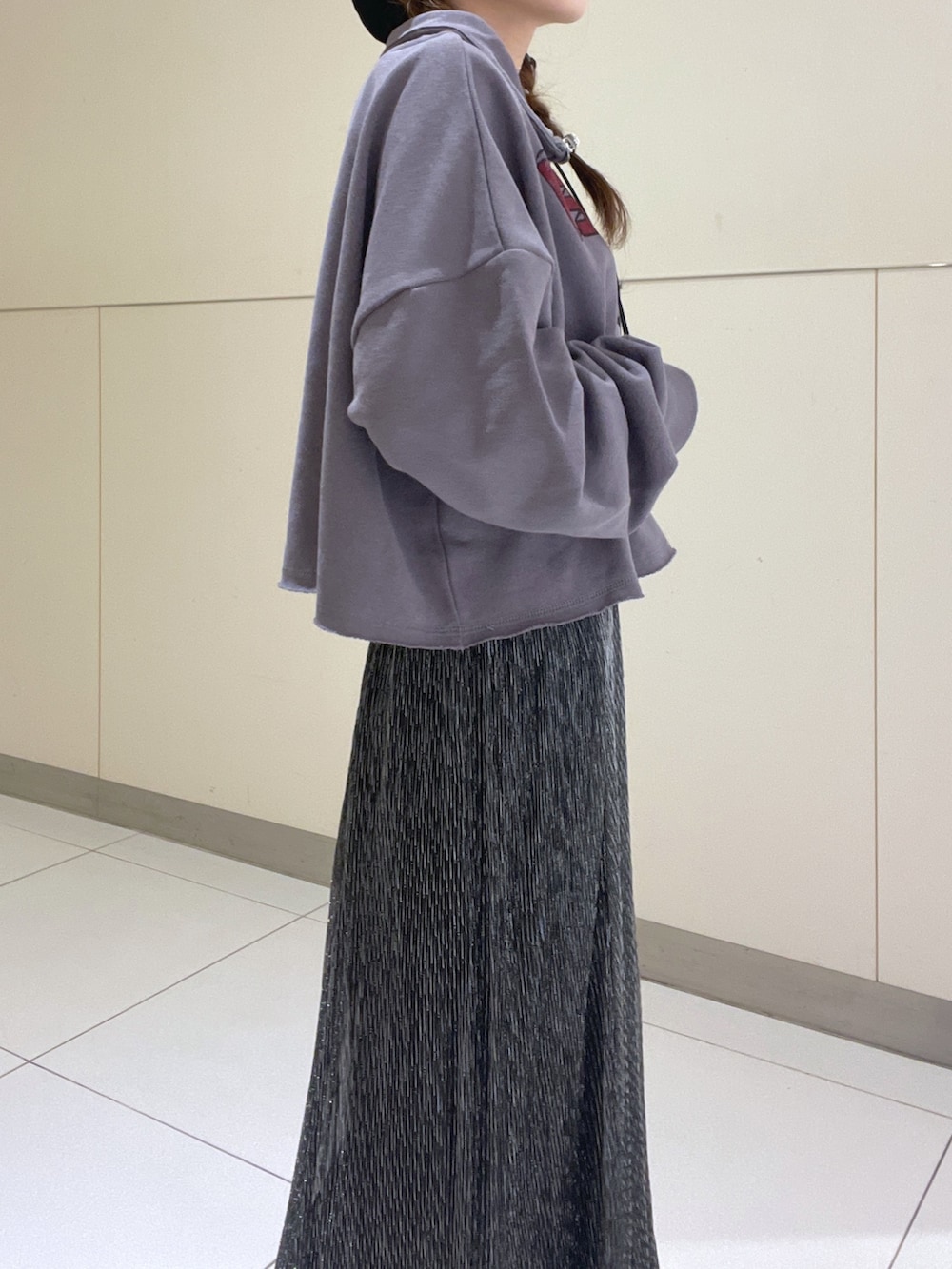 ブラック系のスウェット、ゴールド系のスカートを着用したレディースの秋コーディネートの2枚目の写真