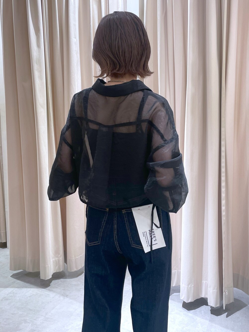 ブラック系のシャツ/ブラウス、ブルー系のデニムパンツを着用したレディースの春コーディネートの2枚目の写真