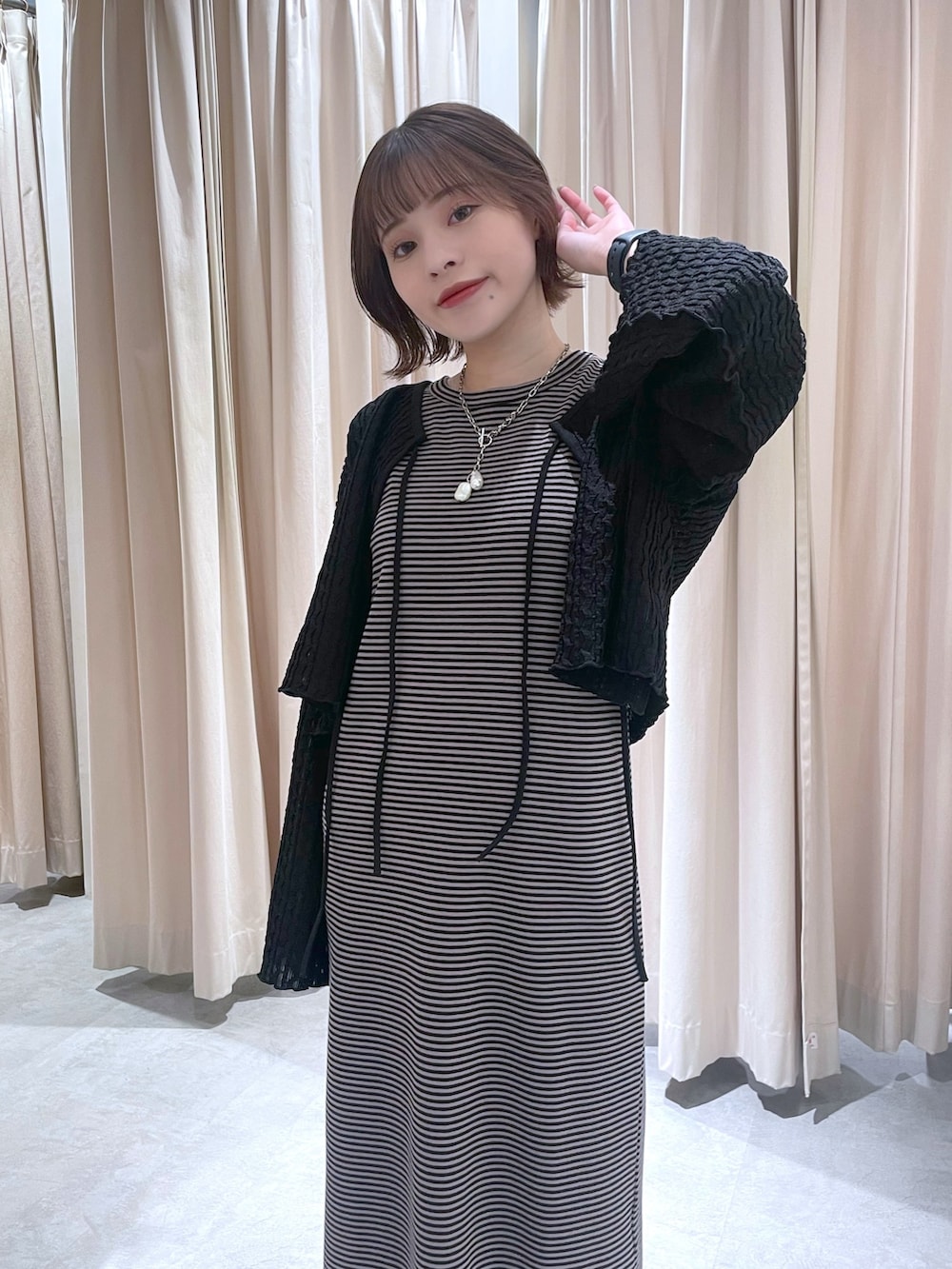 ブラック系のカーディガン/ボレロ、ブラウン系のワンピースを着用したレディースの春コーディネートの2枚目の写真