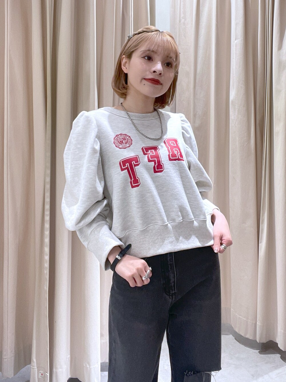 ホワイト系のスウェット、ブラック系のデニムパンツを着用したレディースの春コーディネートの2枚目の写真