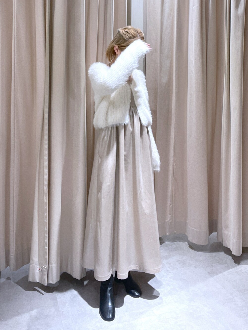 ホワイト系のカーディガン/ボレロ、ベージュ系のワンピースを着用したレディースの冬コーディネートの2枚目の写真