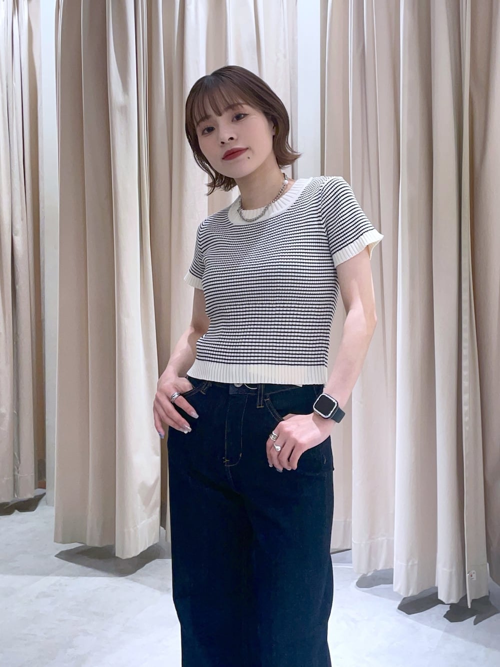 ホワイト系のニット/セーター、ブルー系のデニムパンツを着用したレディースの春コーディネートの2枚目の写真