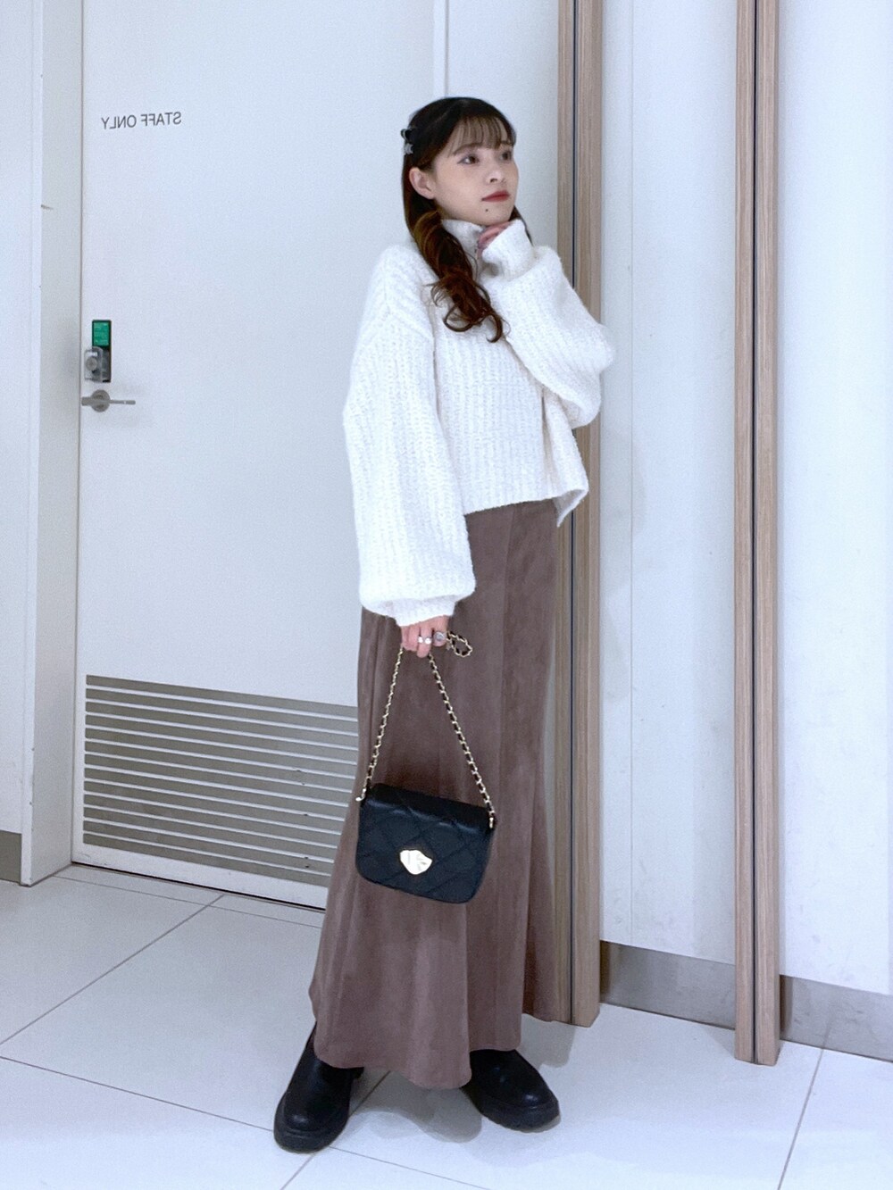 ホワイト系のニット/セーター、ブラウン系のスカートを着用したレディースの秋コーディネートの2枚目の写真