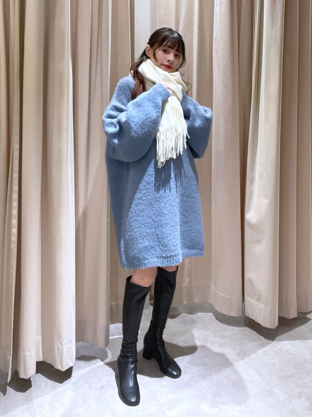 ブルー系のワンピース、ホワイト系のマフラーを着用したレディースの冬コーディネートの2枚目の写真