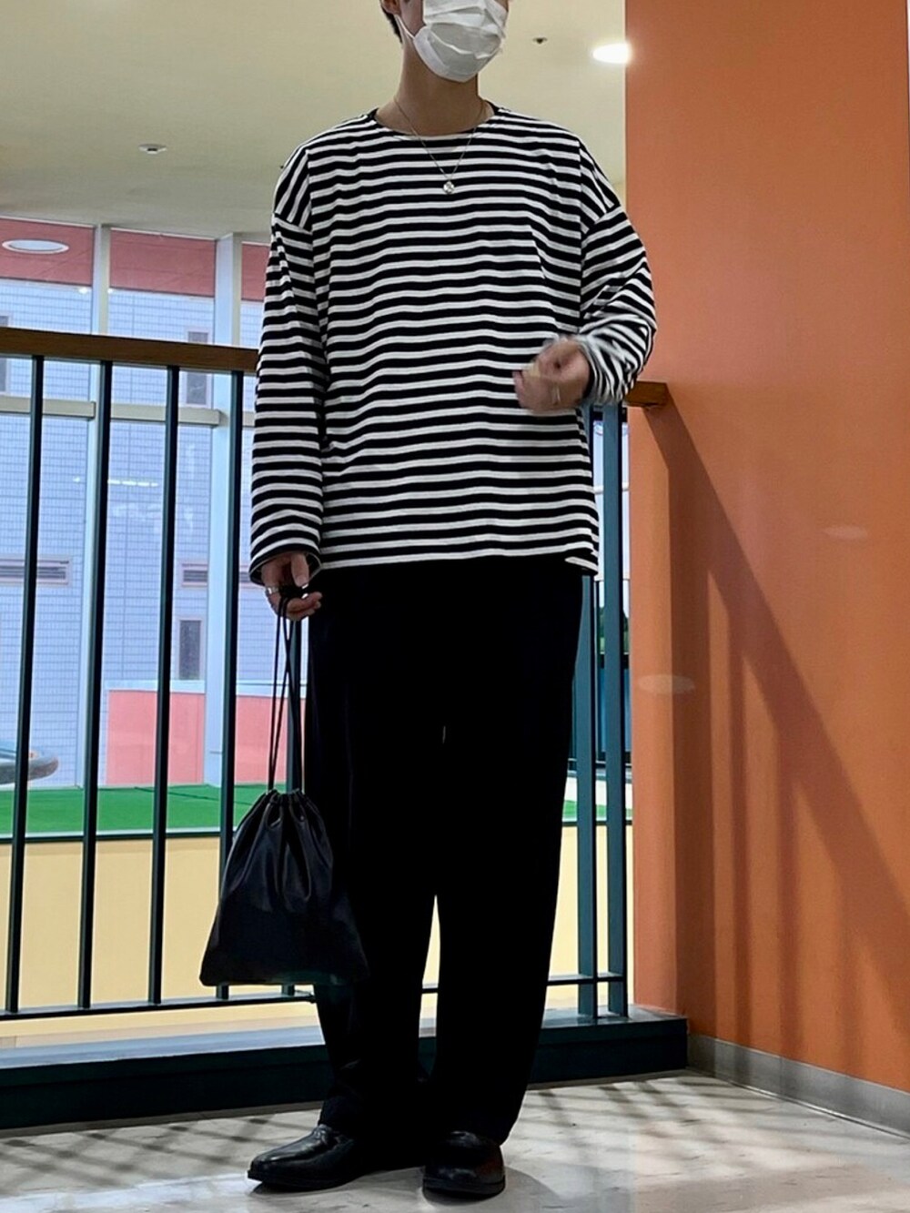 ブラック系のTシャツ/カットソー、グレー系のセットアップ、ブラック系のシューズを着用したメンズの秋コーディネートの2枚目の写真