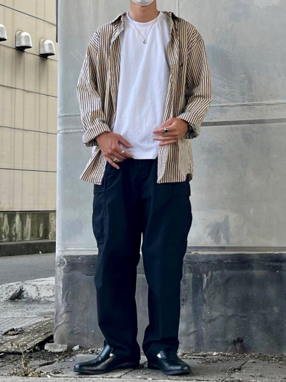 イエロー系のシャツ/ブラウス、ホワイト系のTシャツ/カットソー、ブラック系のカーゴパンツを着用したメンズの秋コーディネートの3枚目の写真