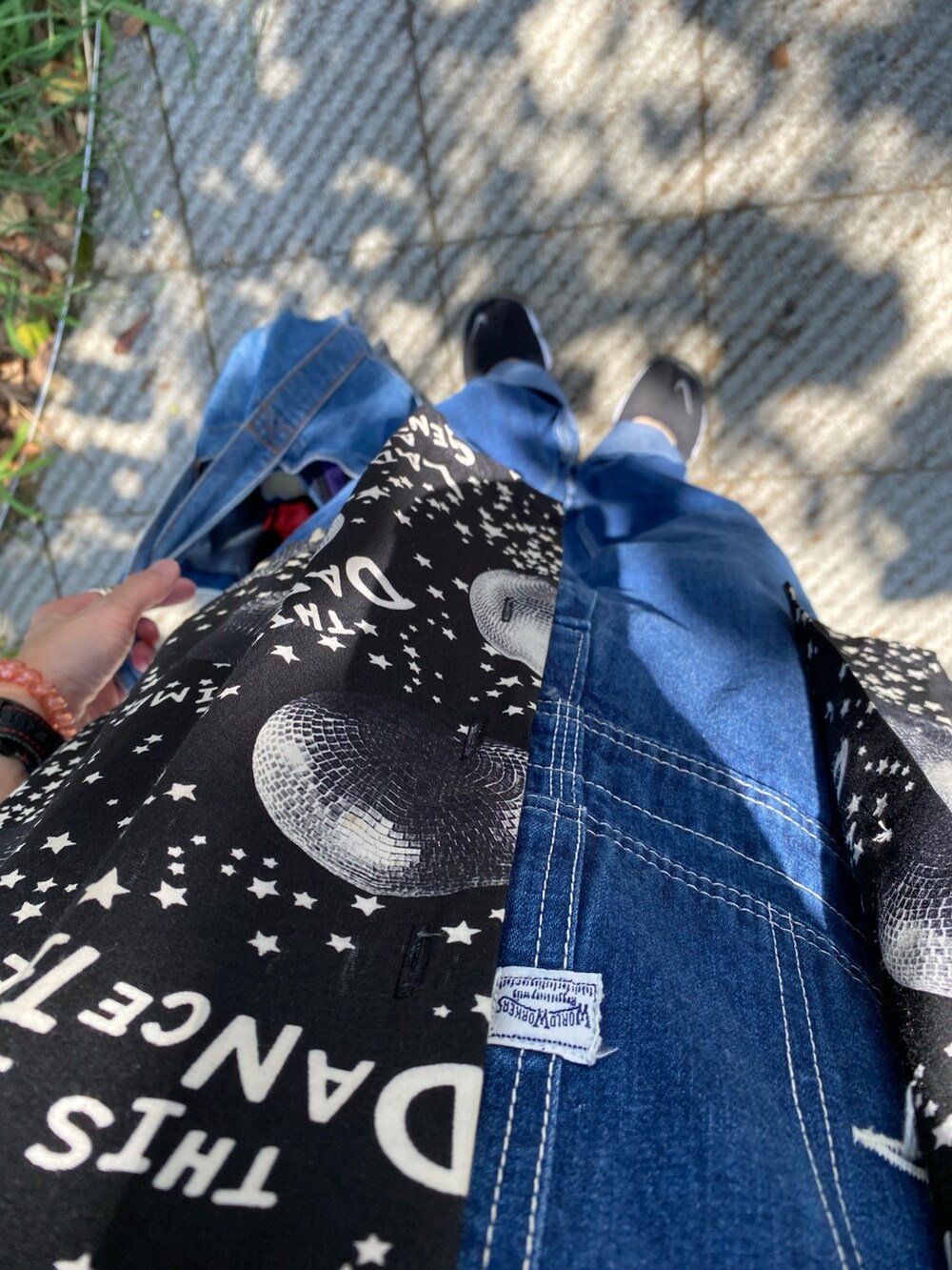 ブラック系のシャツ/ブラウス、ブルー系のサロペット/オーバーオール、ベージュ系のハットを着用したレディースの夏コーディネートの2枚目の写真