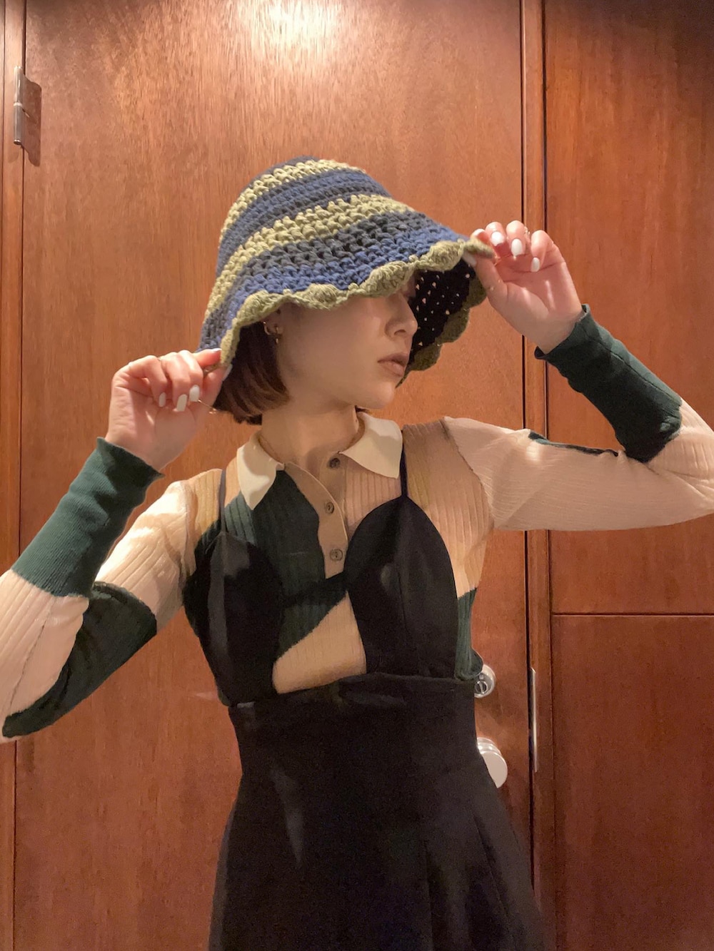 ピンク系のポロシャツ、ブラック系のつなぎ/オールインワン、グリーン系のハットを着用したレディースの春コーディネートの2枚目の写真