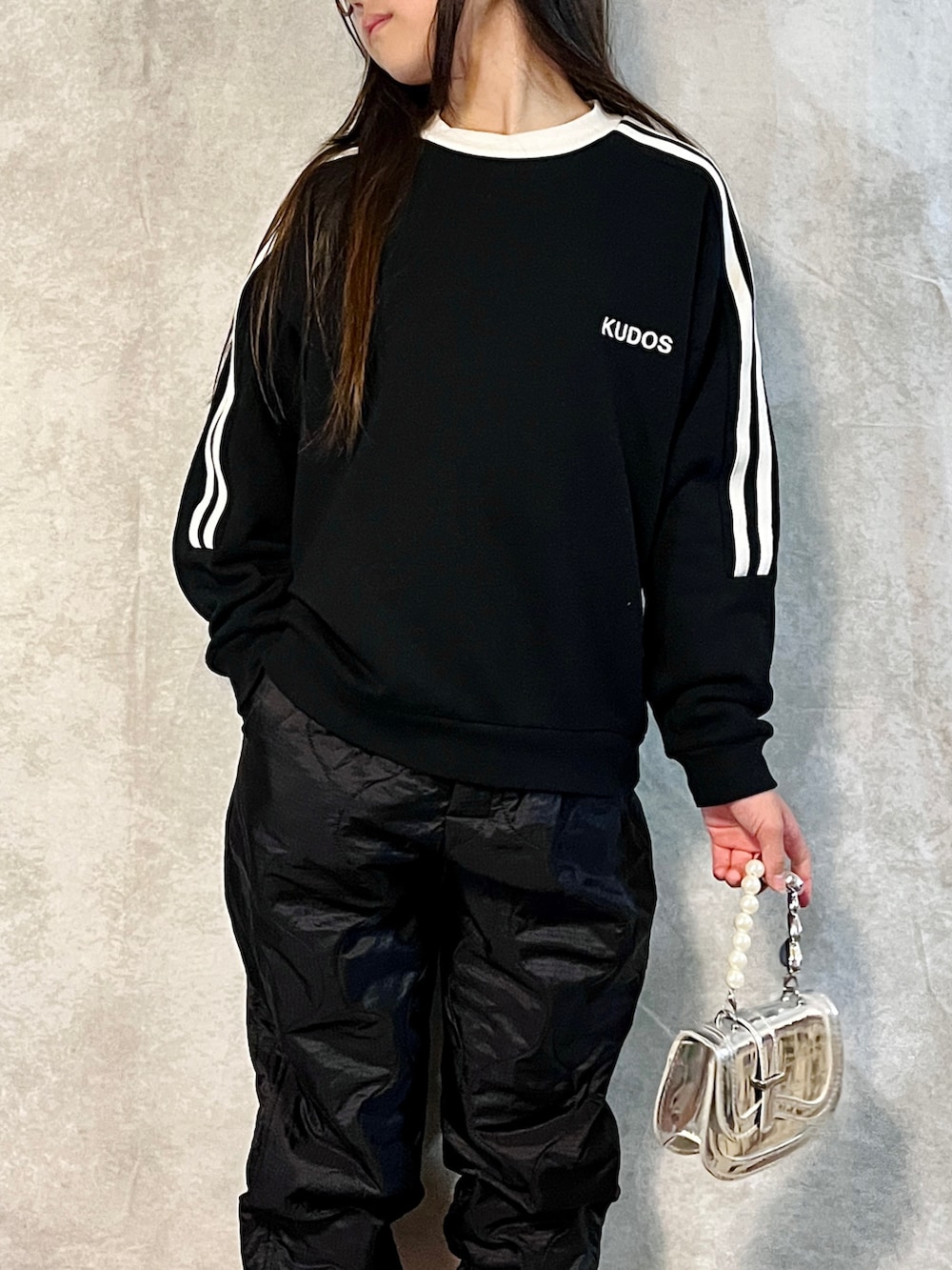 ブラック系のスウェット、ブラック系のその他パンツ、シルバー系のハンドバッグを着用したキッズの秋コーディネートの4枚目の写真