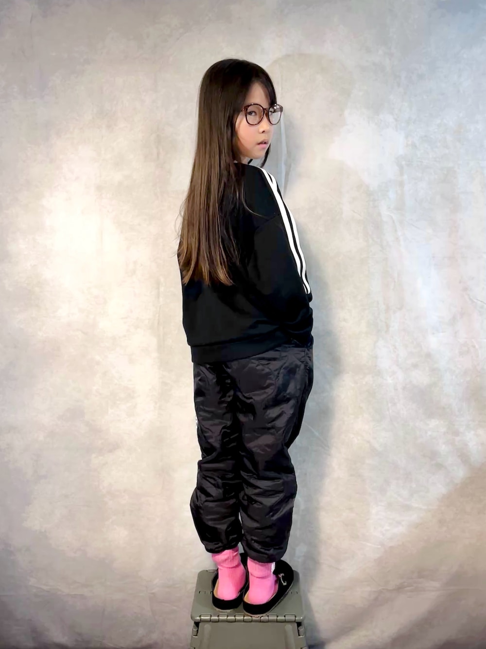 ブラック系のスウェット、ブラック系のその他パンツ、シルバー系のハンドバッグを着用したキッズの秋コーディネートの3枚目の写真