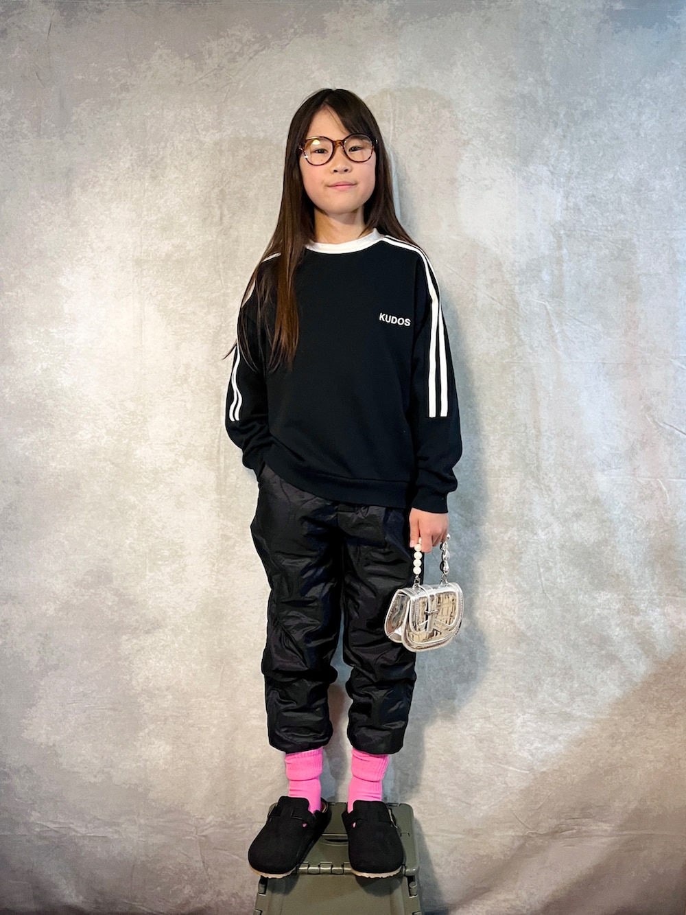 ブラック系のスウェット、ブラック系のその他パンツ、シルバー系のハンドバッグを着用したキッズの秋コーディネートの2枚目の写真