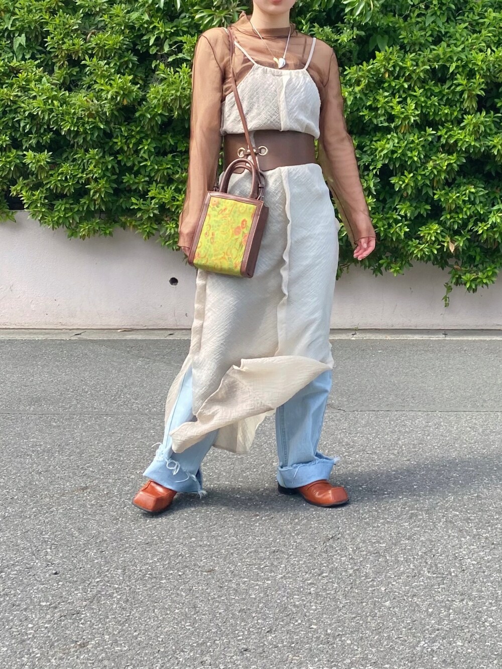 ブラウン系のTシャツ/カットソー、グリーン系のショルダーバッグ、ブラウン系のローファーを着用したレディースの春コーディネートの2枚目の写真