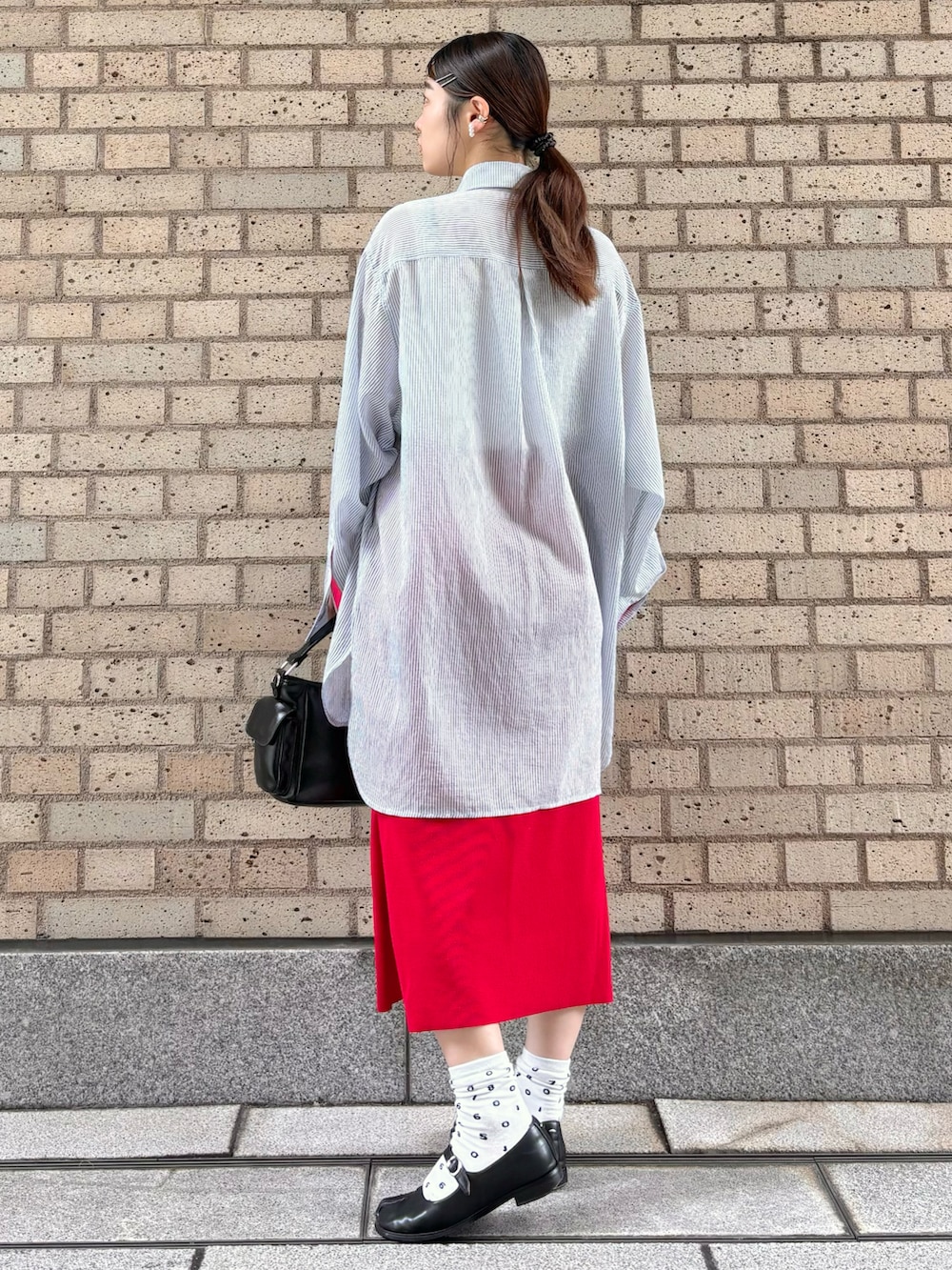 ブルー系のシャツ/ブラウス、ブラック系のショルダーバッグ、レッド系のスカートを着用したレディースの春コーディネートの3枚目の写真