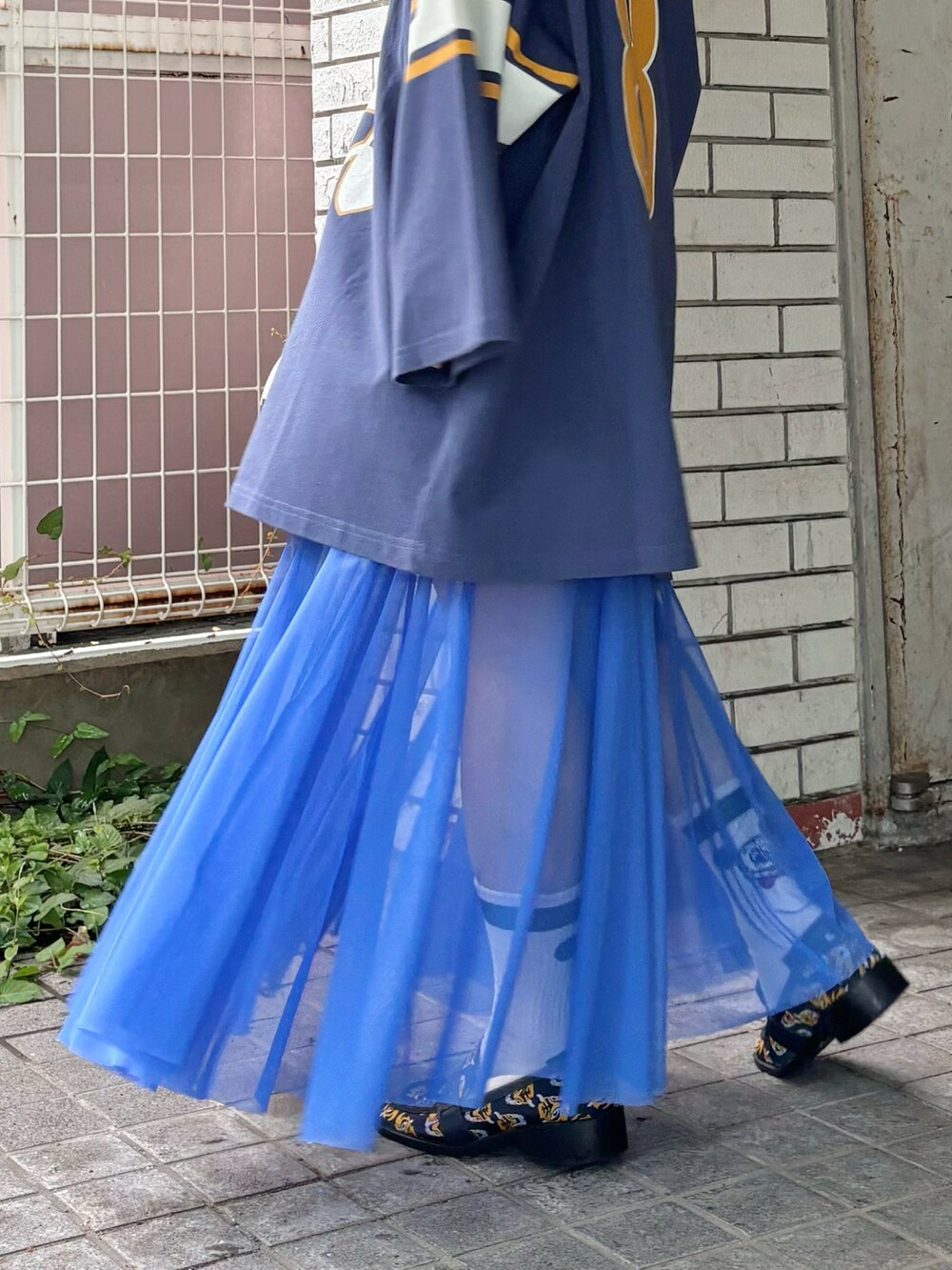 ブルー系のスカート、ブルー系のTシャツ/カットソー、ブルー系のローファーを着用したレディースの秋コーディネートの3枚目の写真