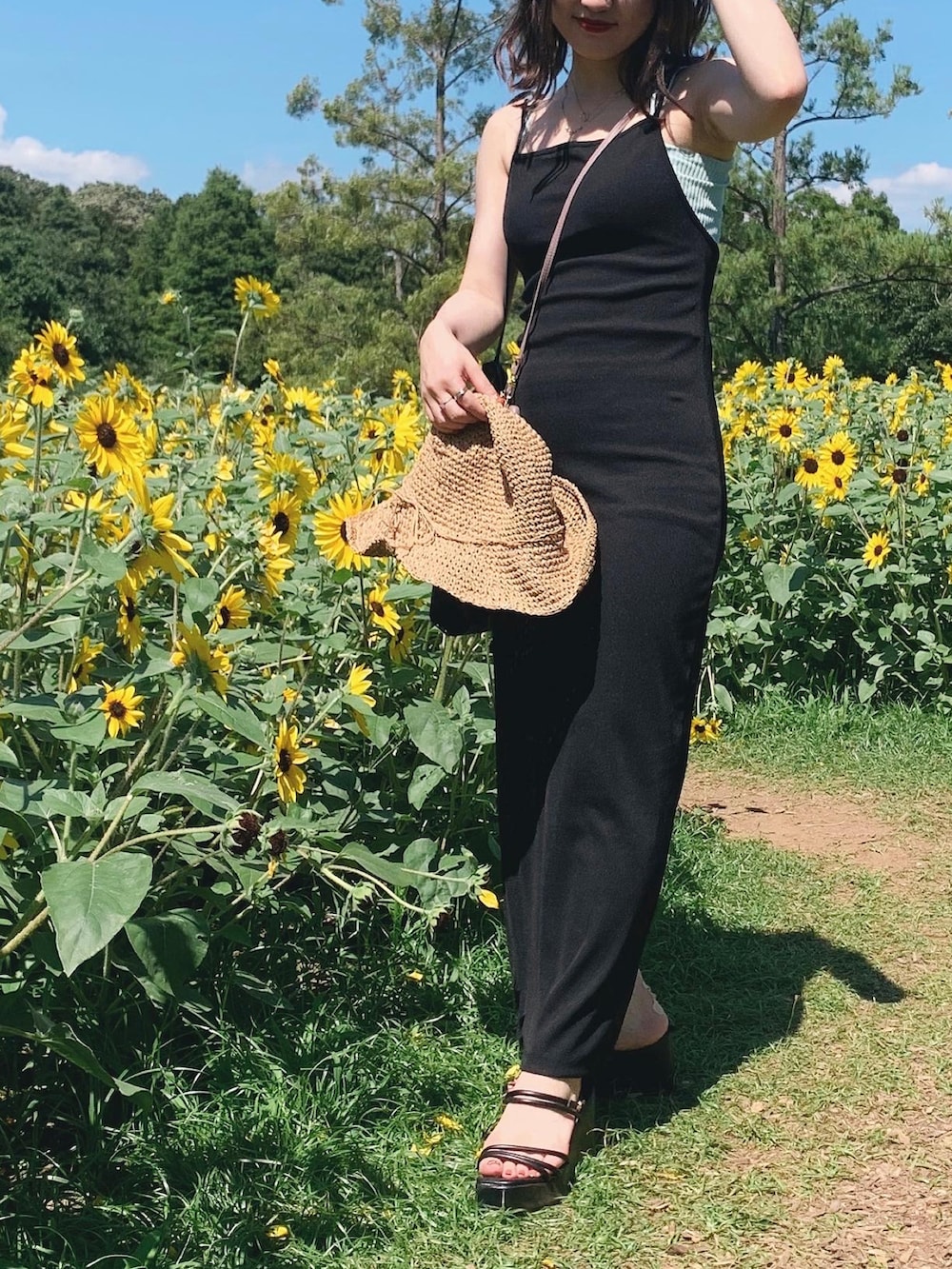 ブラック系のサンダル、ブラック系のワンピース、ベージュ系のハットを着用したレディースの秋コーディネートの2枚目の写真