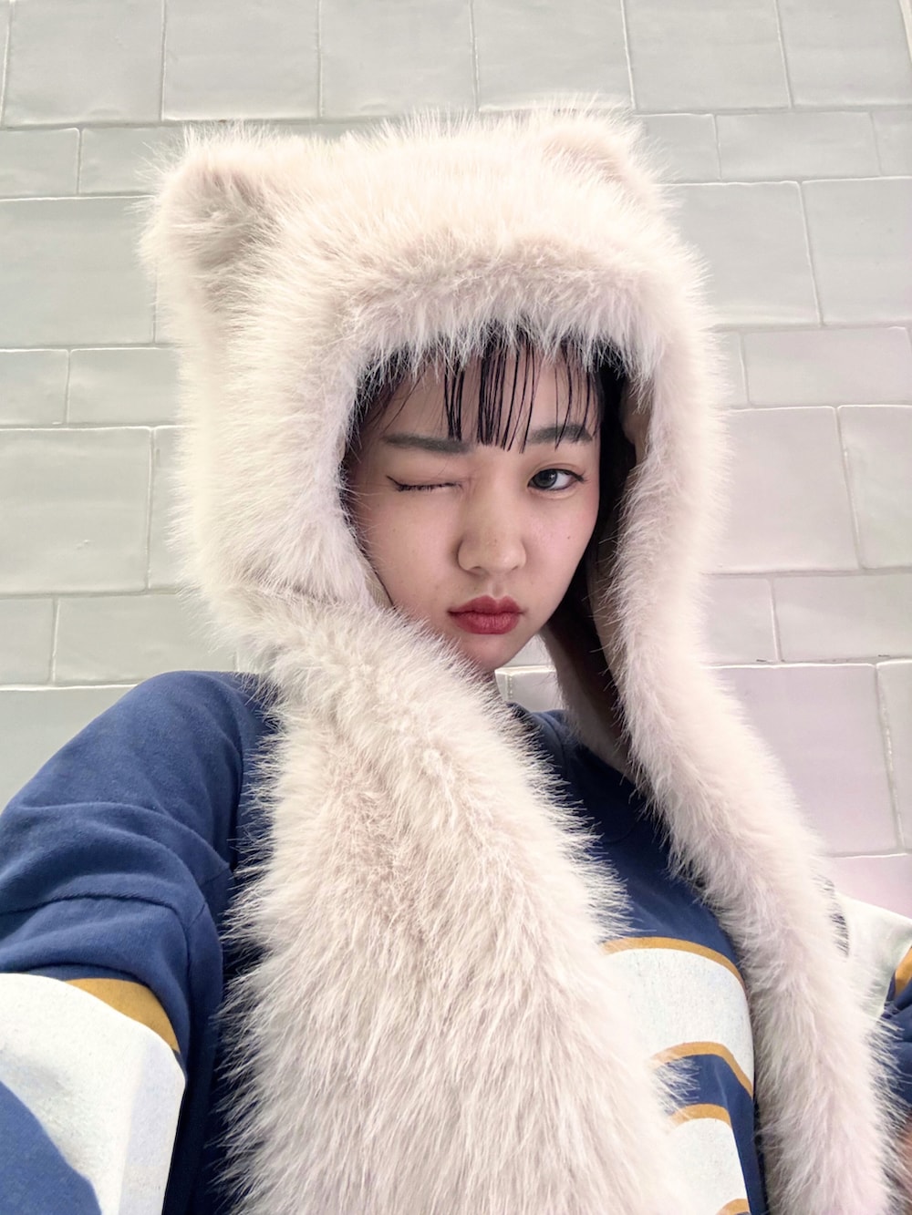 ブルー系のTシャツ/カットソー、グレー系のスニーカー、ホワイト系のマフラーを着用したレディースの秋コーディネートの2枚目の写真