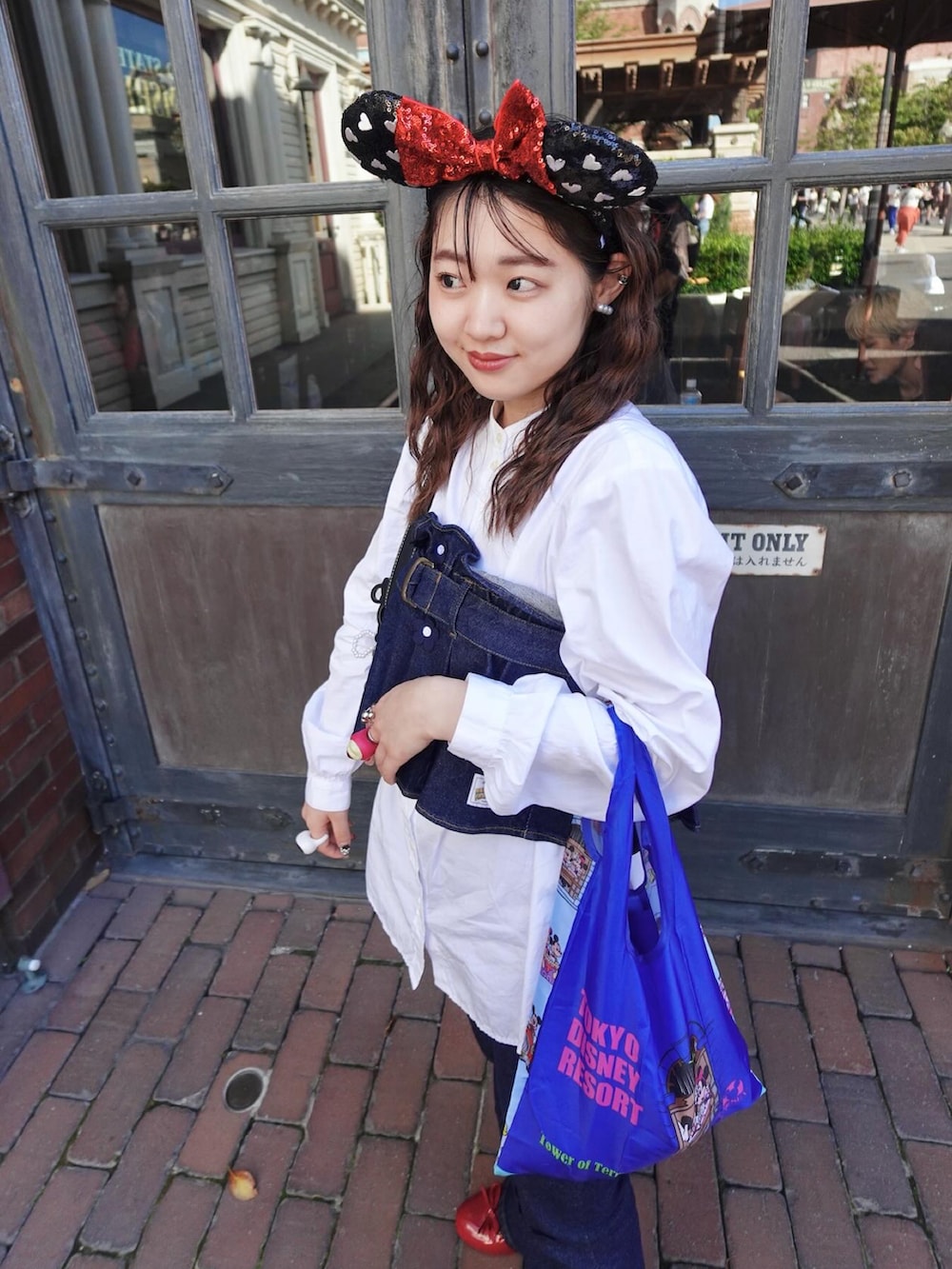 ブルー系のデニムパンツ、ブルー系のベストを着用したレディースの夏コーディネートの3枚目の写真