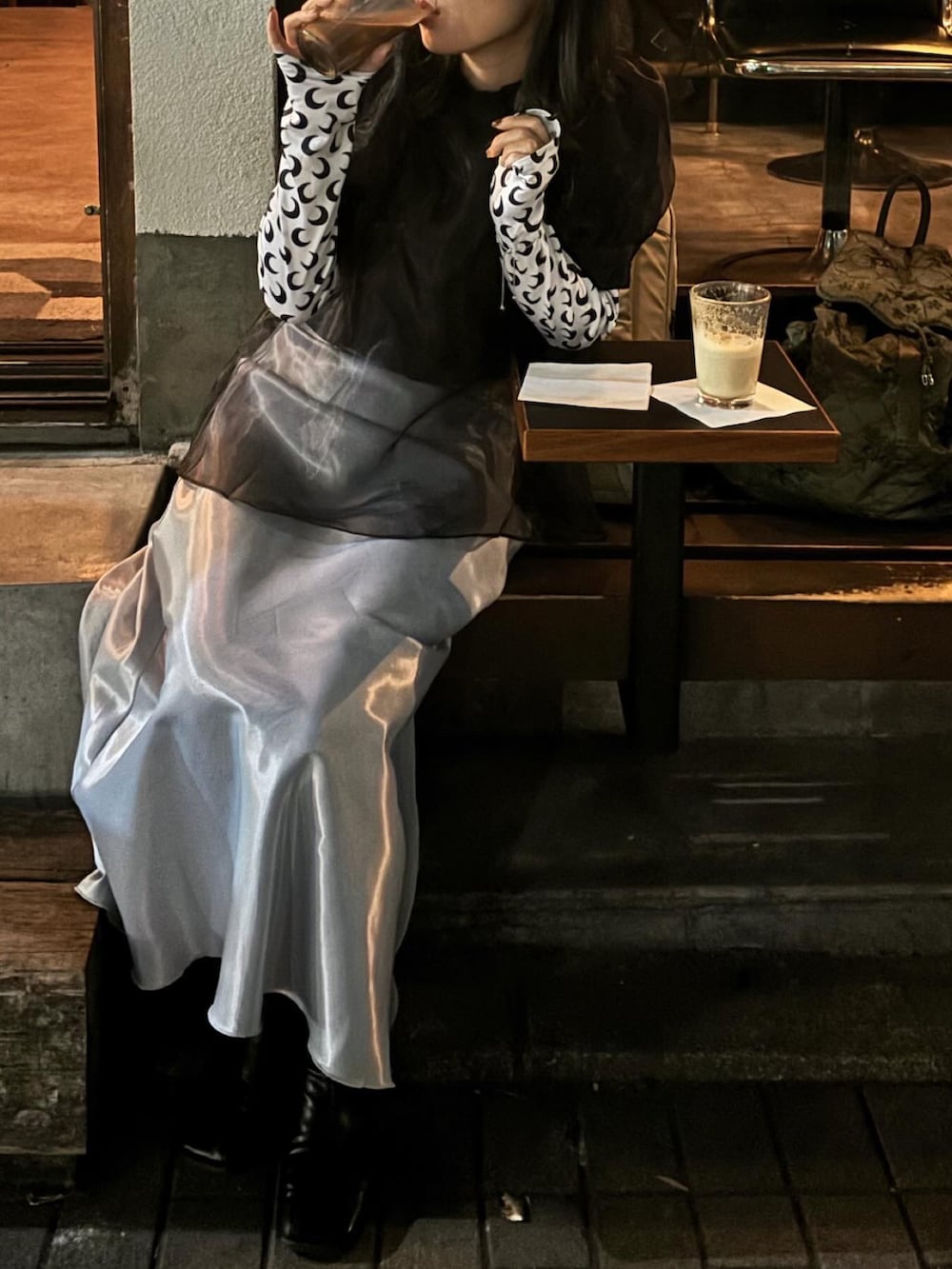 ブラック系のブーツ、グレー系のスカート、ブラック系のトップスを着用したレディースの秋コーディネートの2枚目の写真