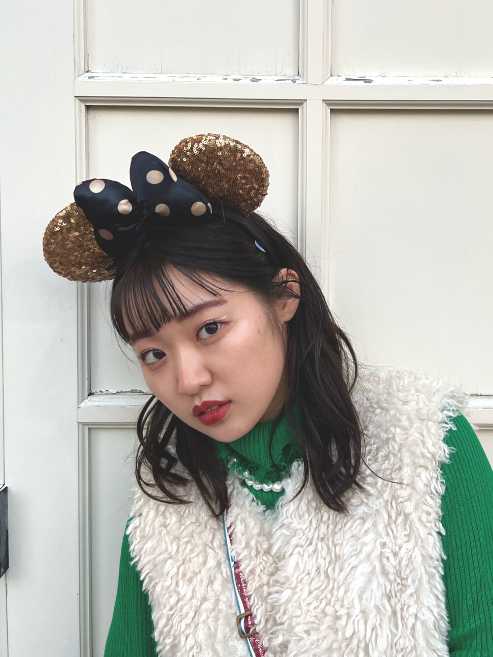 グリーン系のトートバッグ、レッド系のパンツ、シルバー系のブーツを着用したレディースの冬コーディネートの3枚目の写真