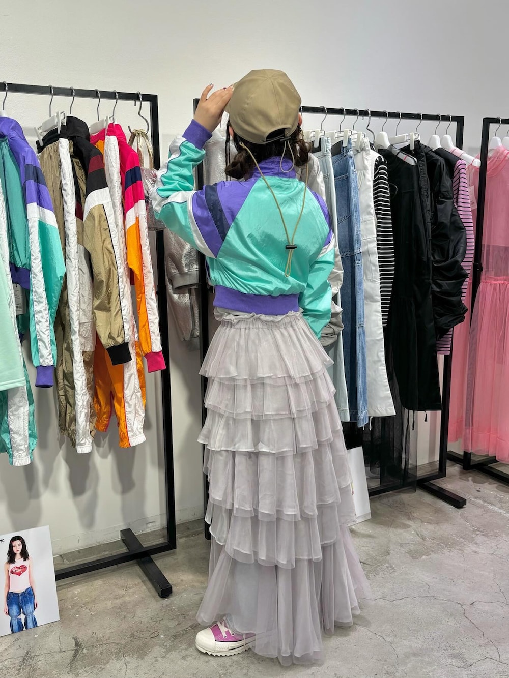 ピンク系のスニーカー、ブルー系のデニムパンツ、パープル系のナイロンジャケットを着用したレディースの春コーディネートの3枚目の写真