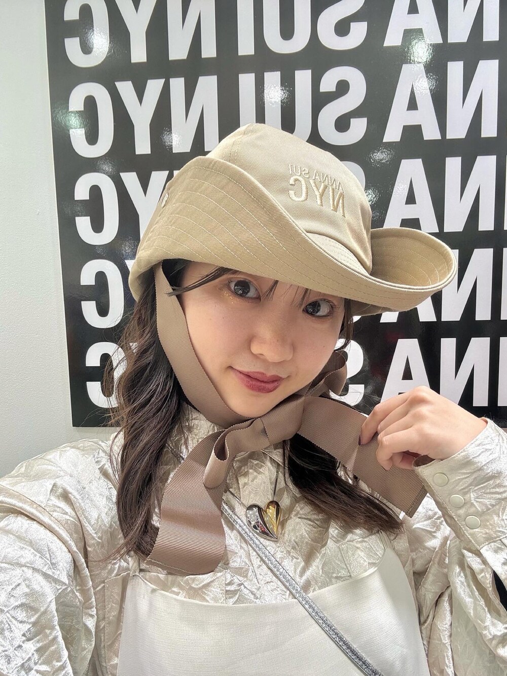 ベージュ系のハットを着用したレディースの春コーディネートの2枚目の写真