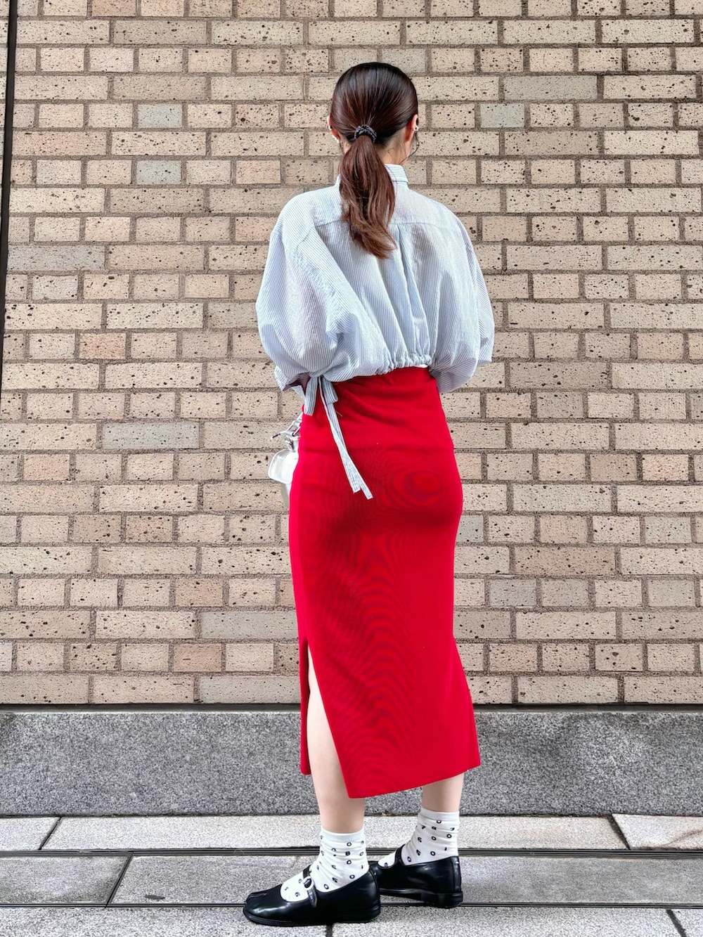 ブルー系のシャツ/ブラウス、レッド系のスカート、シルバー系のショルダーバッグを着用したレディースの春コーディネートの2枚目の写真
