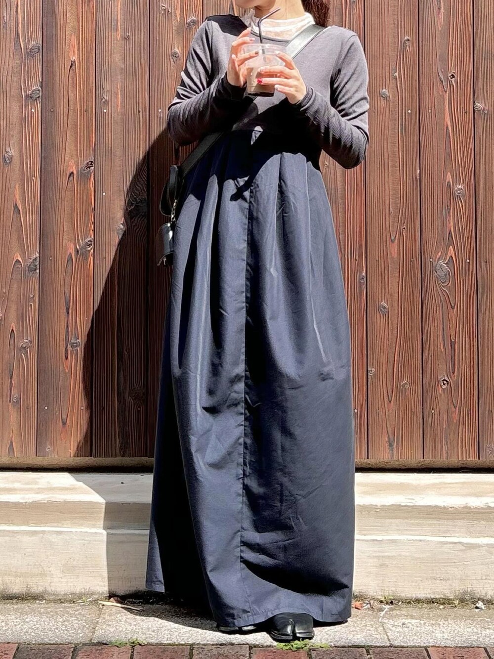 グレー系のワンピース、ブラック系のバレエシューズを着用したレディースの夏コーディネートの2枚目の写真