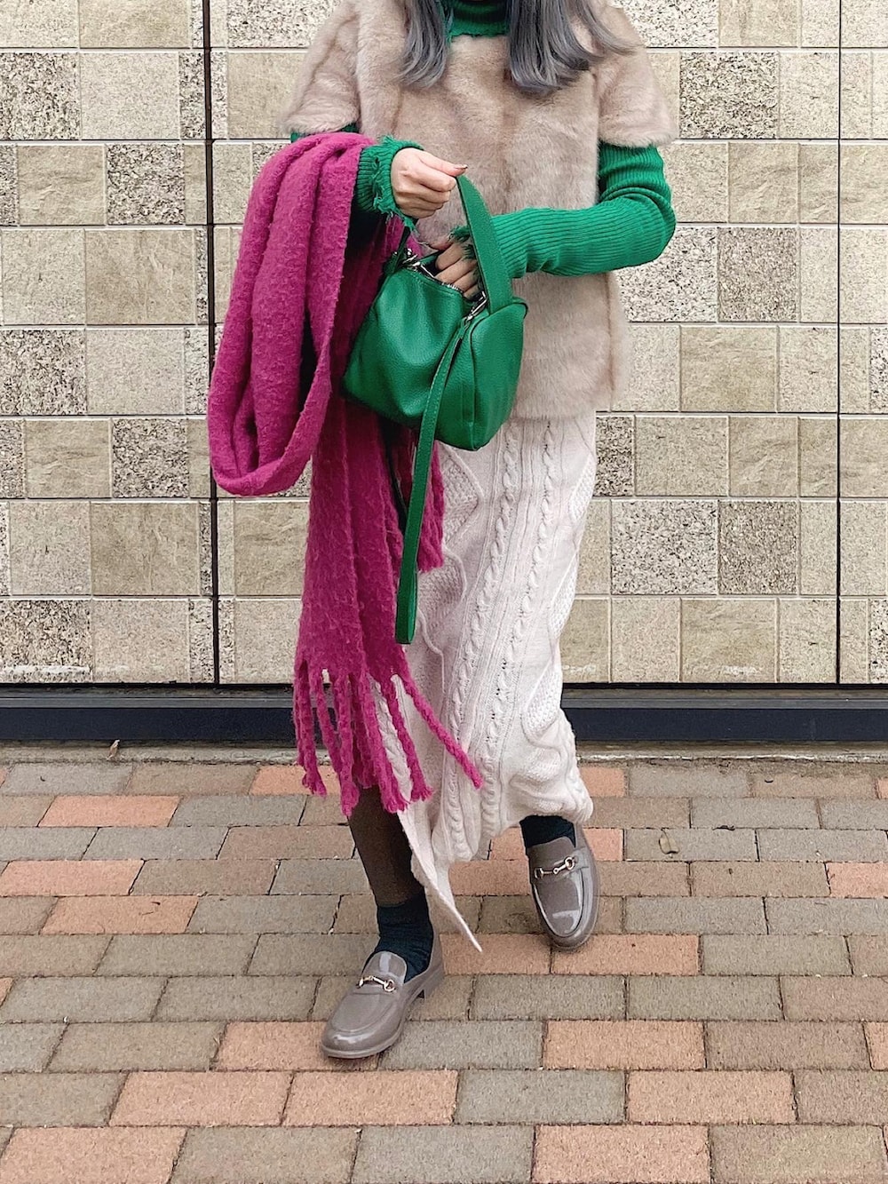 ホワイト系のスカート、グレー系のレインシューズ、グリーン系のバッグを着用したレディースの春コーディネートの3枚目の写真