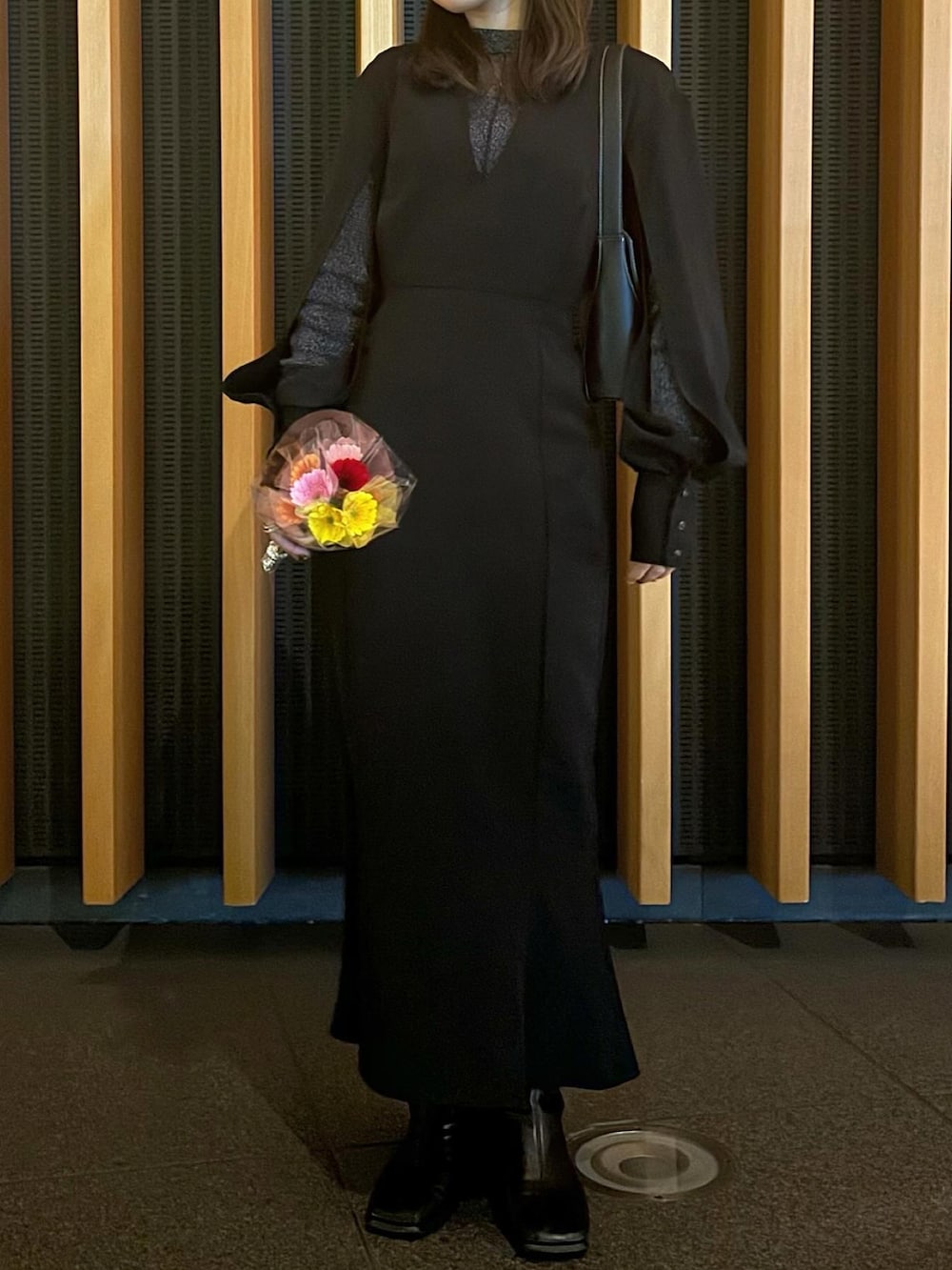 ブラック系のワンピース、ブラック系のブーツを着用したレディースの冬コーディネートの2枚目の写真