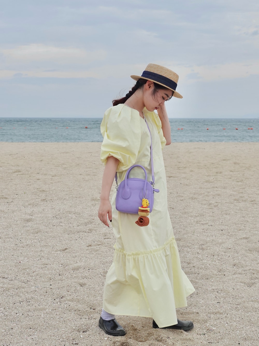 パープル系のハンドバッグを着用したレディースの秋コーディネートの2枚目の写真