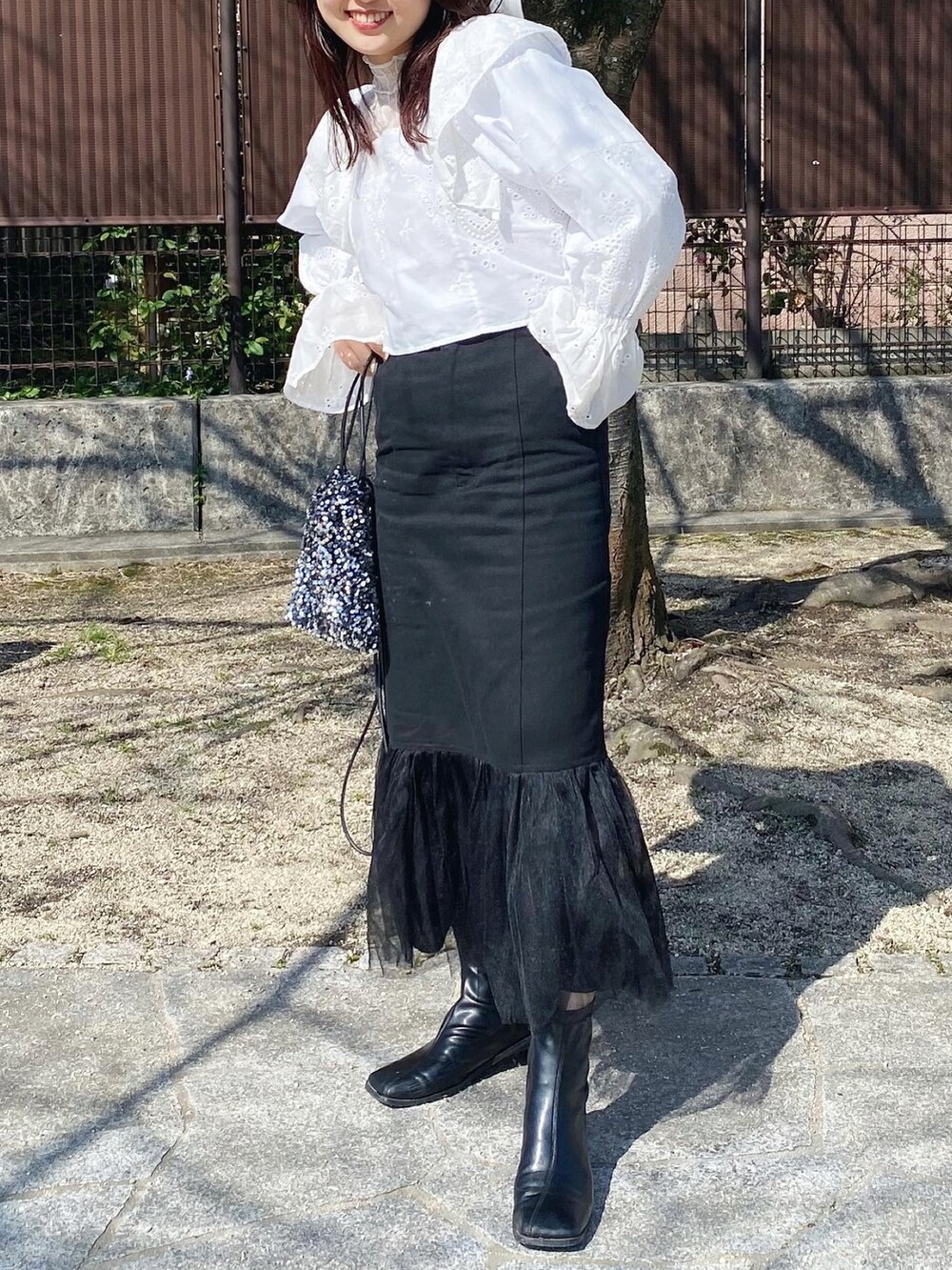 ホワイト系のシャツ/ブラウス、ブラック系のワンピース、ブラック系のスカートを着用したレディースの春コーディネートの2枚目の写真