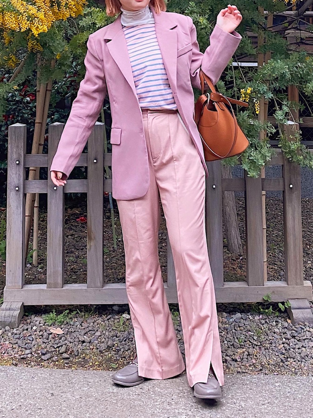 ピンク系のその他パンツ、オレンジ系のバッグ、ピンク系のTシャツ/カットソーを着用したレディースの春コーディネートの2枚目の写真