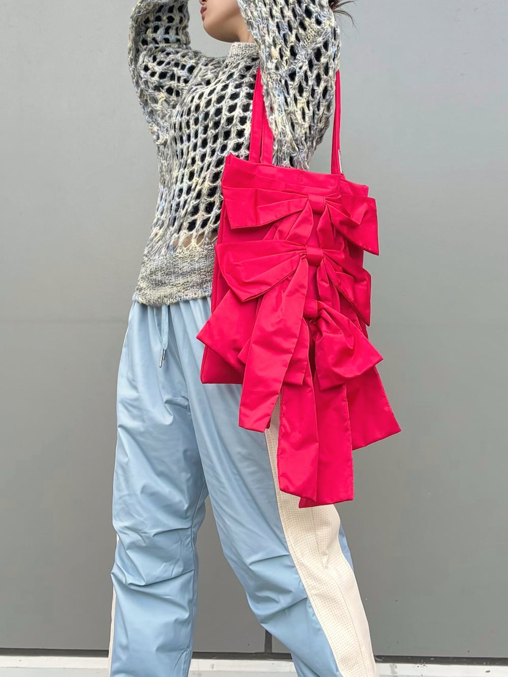 ブルー系のその他パンツ、ブルー系のニット/セーター、レッド系のトートバッグを着用したレディースの秋コーディネートの2枚目の写真